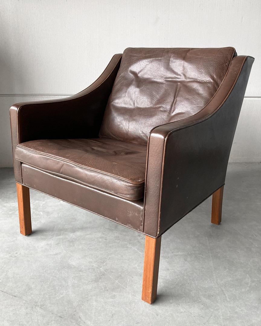 Lounge chair model 2207 by Fredericia Furniture. Design by Børge Mogensen, Draft 1963. Wooden frame construction, teak legs. Upholstered in dark brown premium leather coverings. 

The chair belongs to Fredericia Furnitures Select Collection