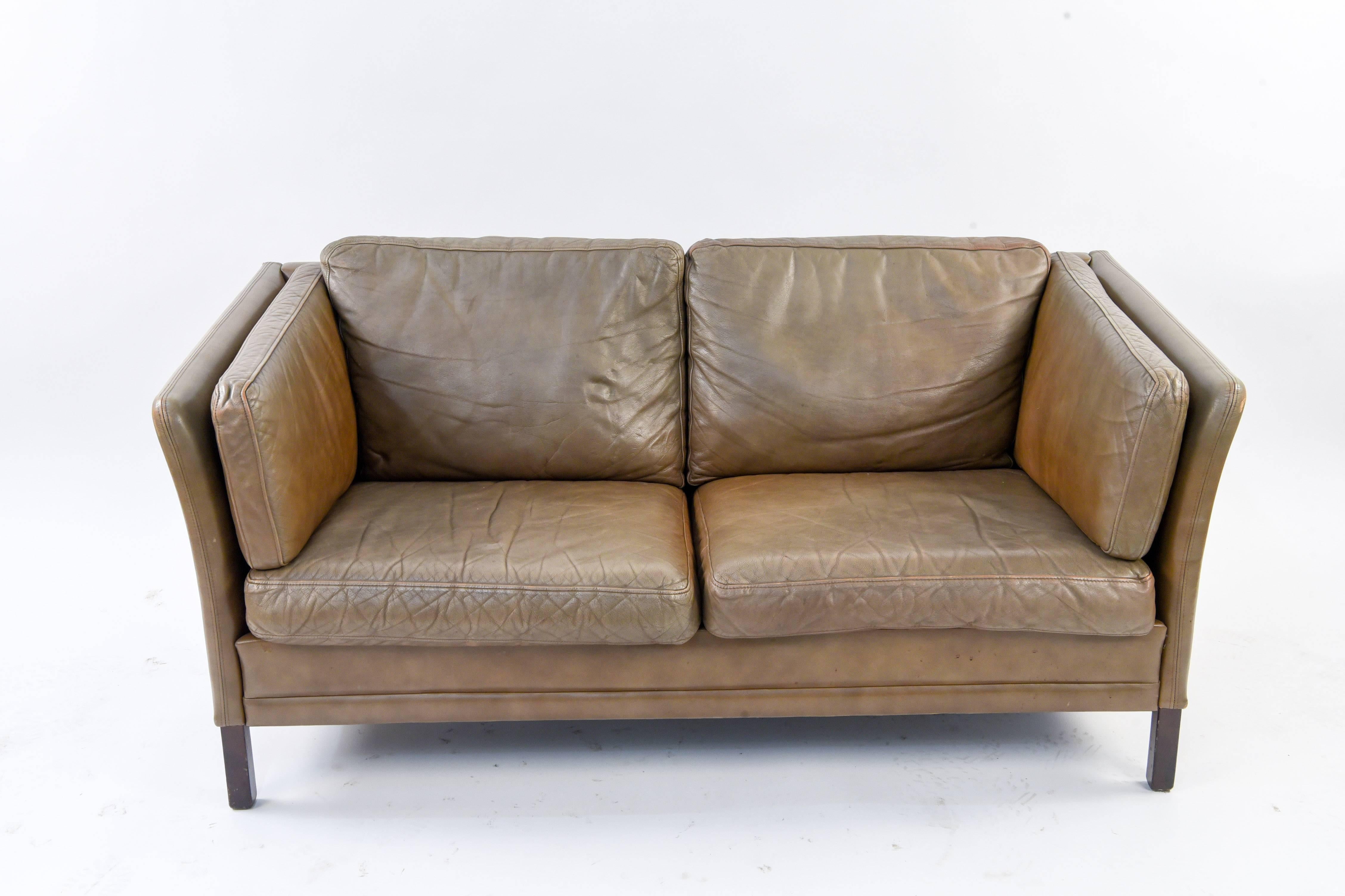 This sofa was designed and made by during the 1960s by Mogens Hansen in the style of the Danish architect and furniture designer Børge Mogensen. It features a wooden frame and is upholstered with brown leather. In good vintage condition.