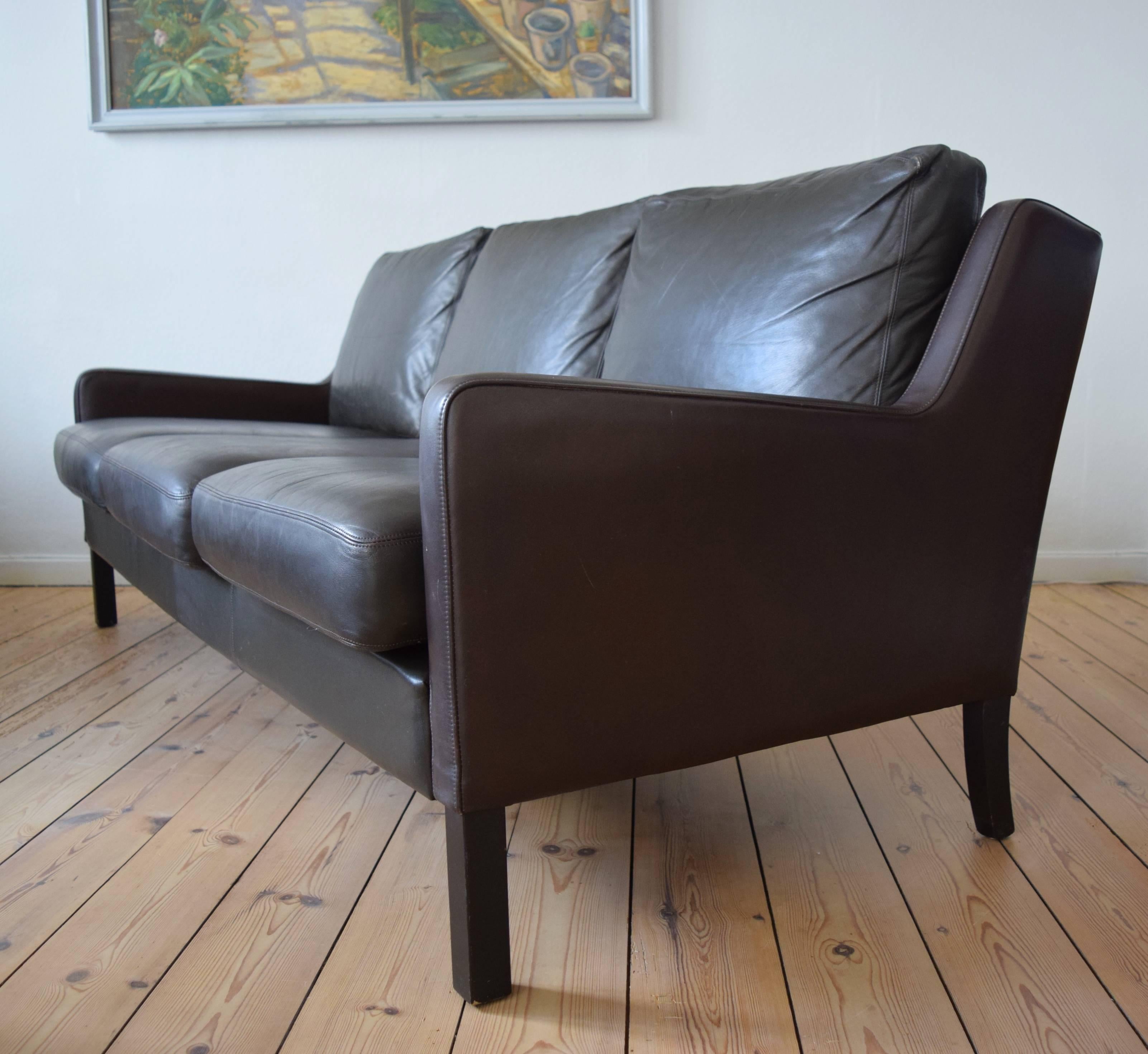 Leather three-person sofa manufactured in Denmark in the 1960s. The low slung design features angular lines and is reminiscent of the 2209 model by Børge Mogensen. The sofa is in very good condition with light wear for its age. The sofa has been
