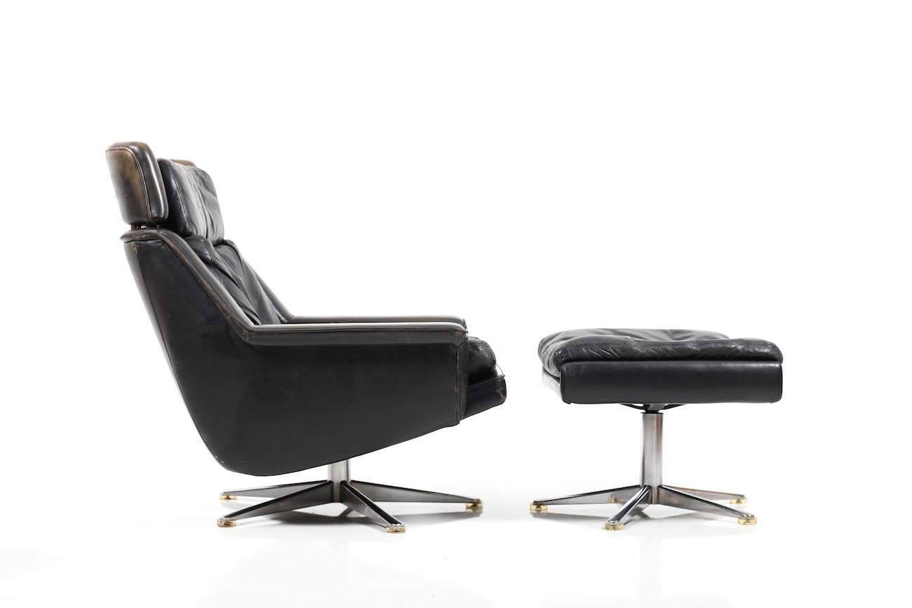 Midcentury Danish lounge chair and ottoman. This items were designed by Werner Langenfeld for ESA Møbelværk in Denmark during the 1970s. Model 802. They are upholstered in black leather and have chromed swivel bases.