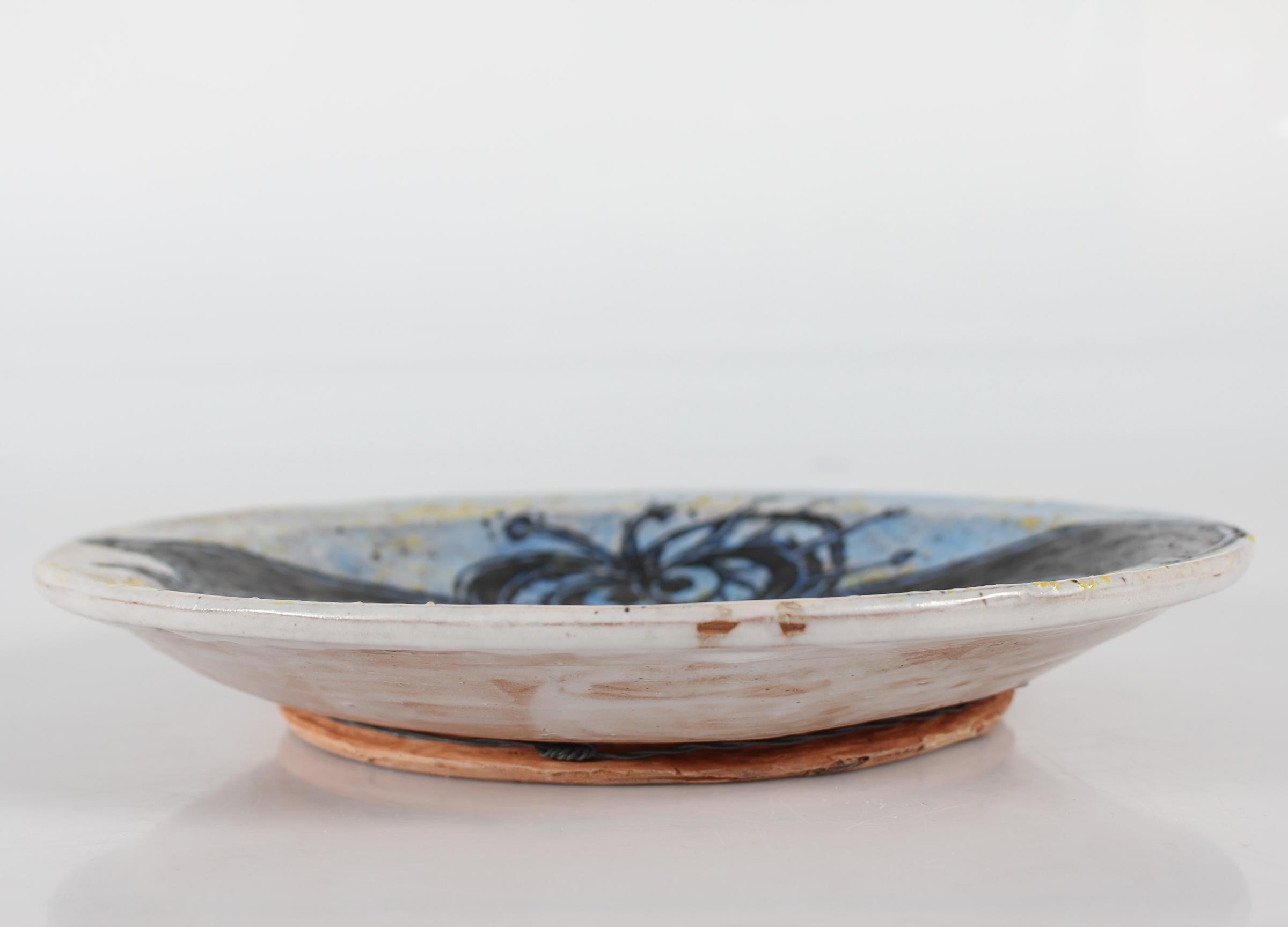 Danish mid-century low ceramic bowl by Leif Messell made at his own ceramic workshop in Sejs, Silkeborg, Denmark in 1997.

The low bowl has a figurative decoration of a flying bat on the inside. Glazed on the inside in black, dark blue, light blue