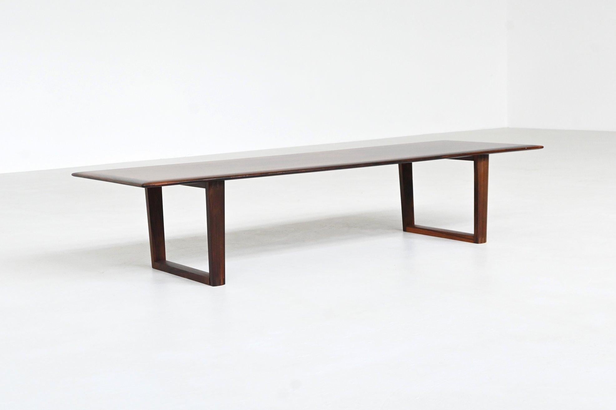 Beautiful long Danish coffee table crafted in richly grained rosewood, Denmark 1960. This elegantly proportioned piece features a sharp rectangular top with gently raised edges, showcasing the natural depth and variation of the wood. The base is