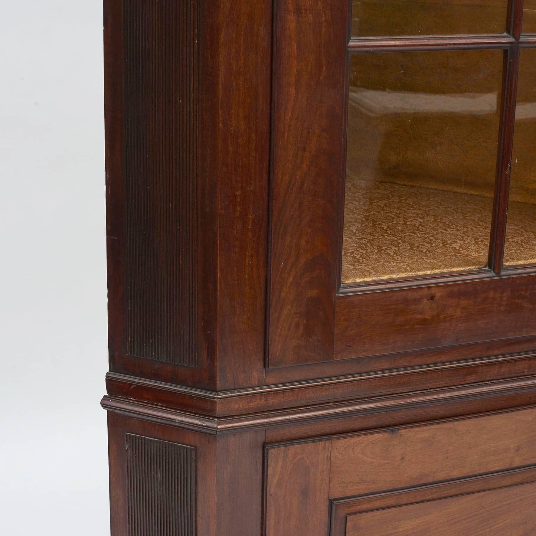 Danish Louis XVI mahogany corner cabinet. Excellent craftsmanship.
In two parts: The upper section with molded dentil cornice above pane glass door. The lower section with paneled door with storage inside. The cabinet has fluted side posts.