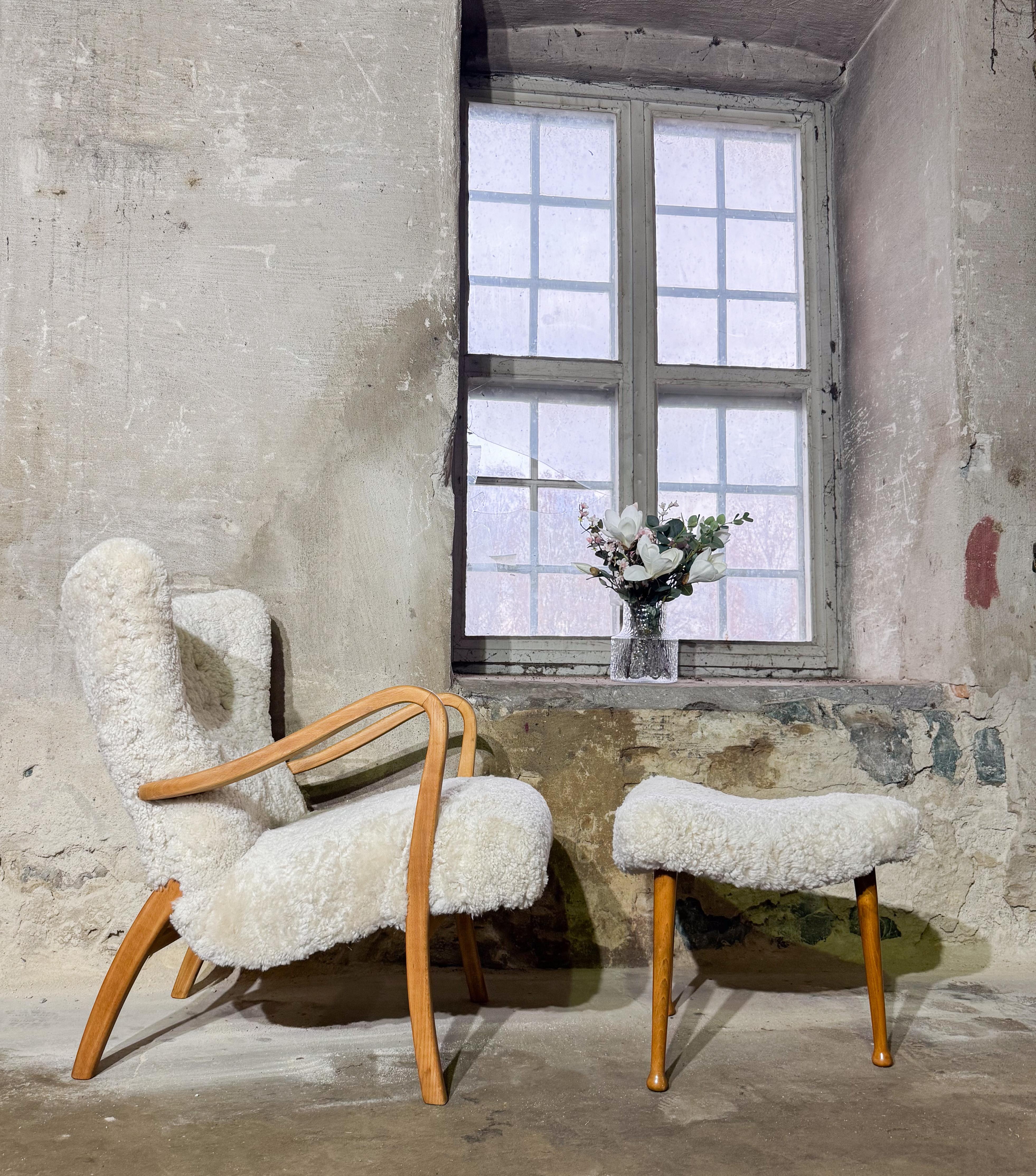 A stunning lounge chair crafted in Denmark in the 1940s. This elegant piece features a beautifully sculpted birchwood frame and has been newly upholstered in moonlight sheepskin by our own workshop. Combining timeless Danish design with exceptional