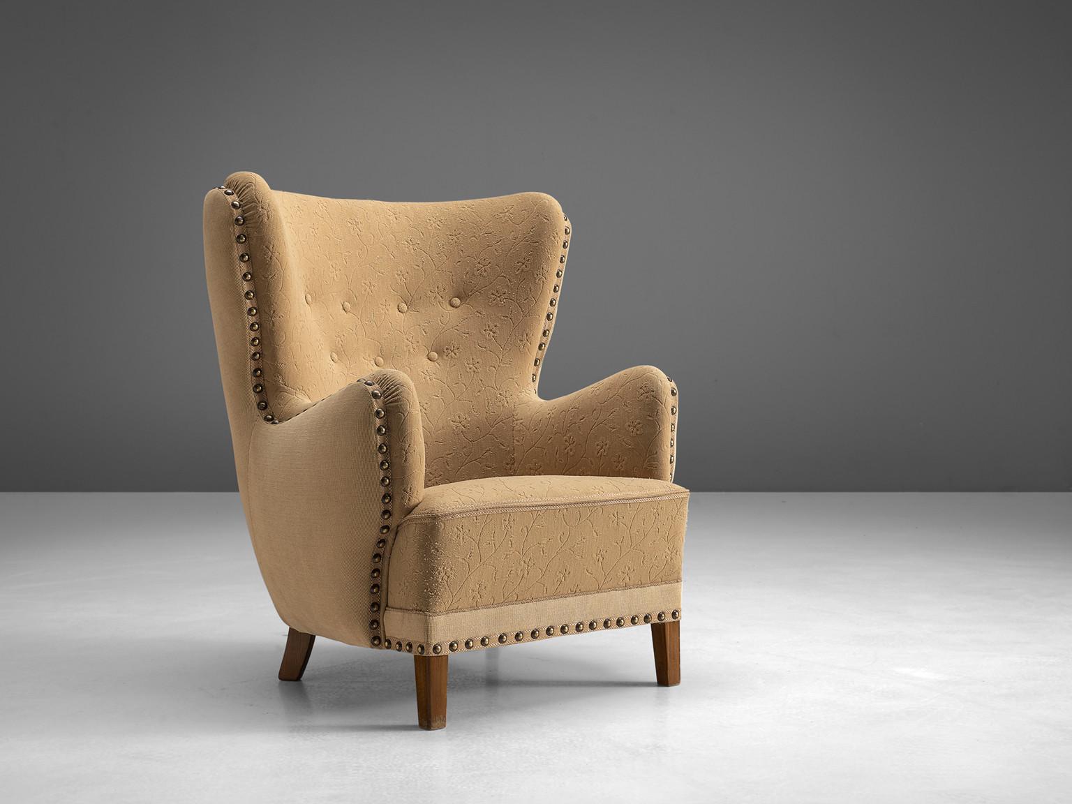 Lounge chair, stained beech, beige fabric, Denmark, 1950s

This archetypical wingback chair of the 1950s is both extremely comfortable and pleasing to the eyes. This easy chair with stained beech legs features a modest wing and buttoned back. The