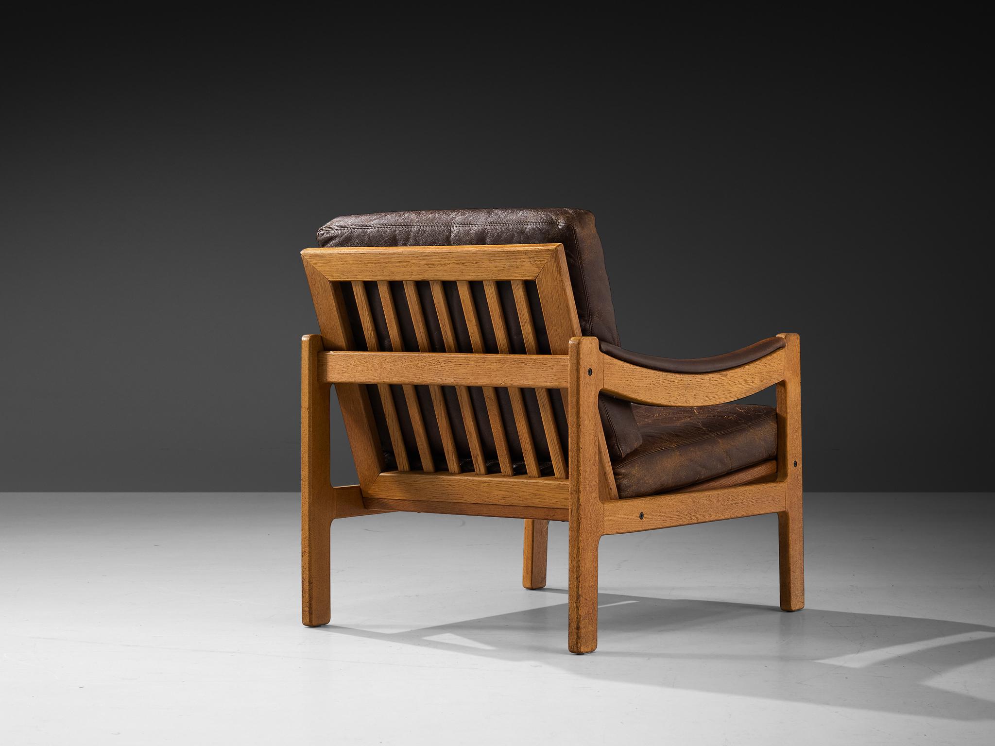 Lounge chair, brown leather, oak, Denmark, 1970s

This armchair is a prime example of Scandinavian Mid-Century design ideology. Clear in its appearance, use of neutral materials, and expert craftsmanship  characterize this chair. A distinctive