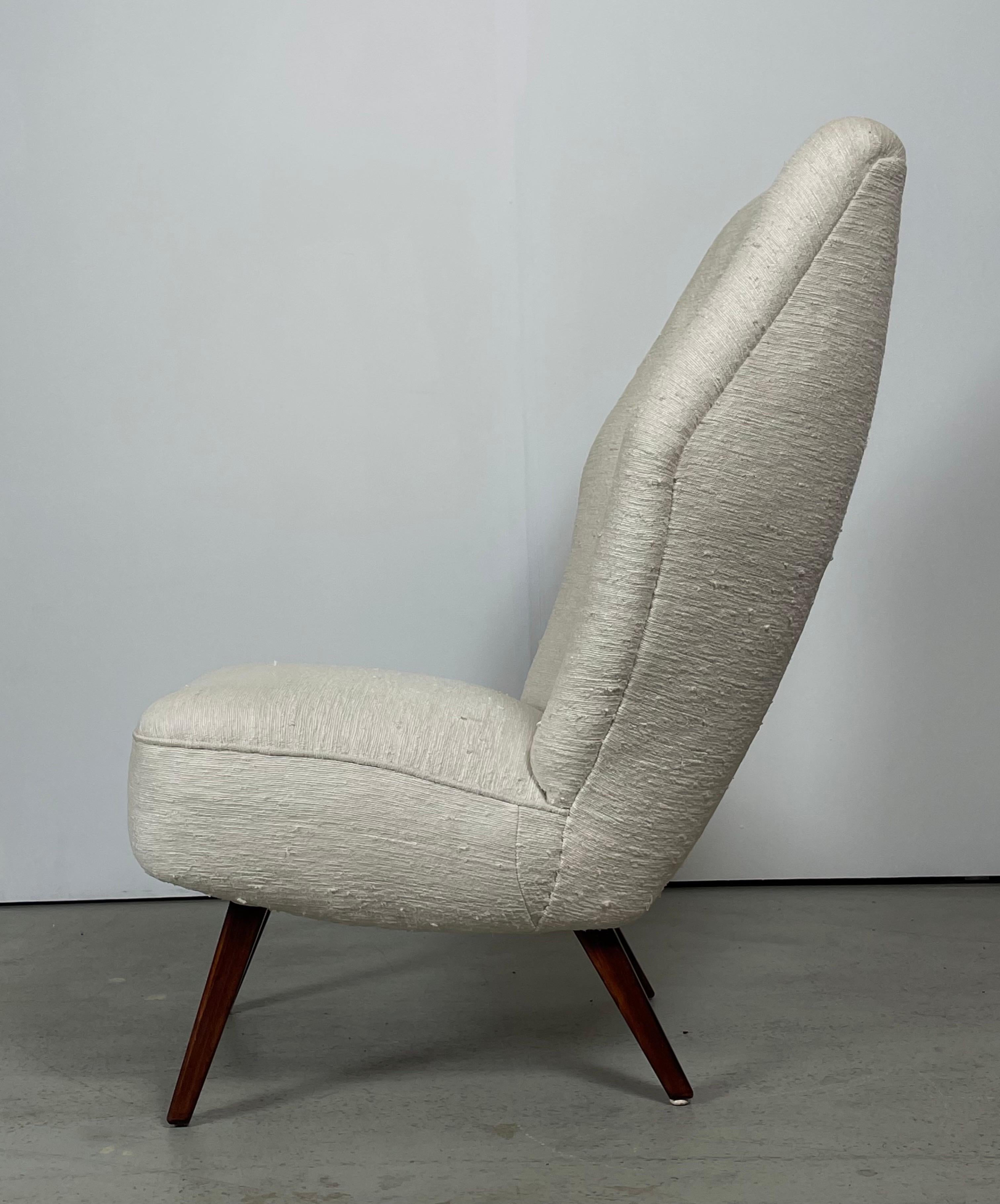 A rare high back chair in very elegant and comfortable design. Manufactured in Denmark durng the 1930s - 1940s. The conditions is vintage and still very good and firm. The previous owner has renew the upholstery in a silk-woolen fabric (off-white).