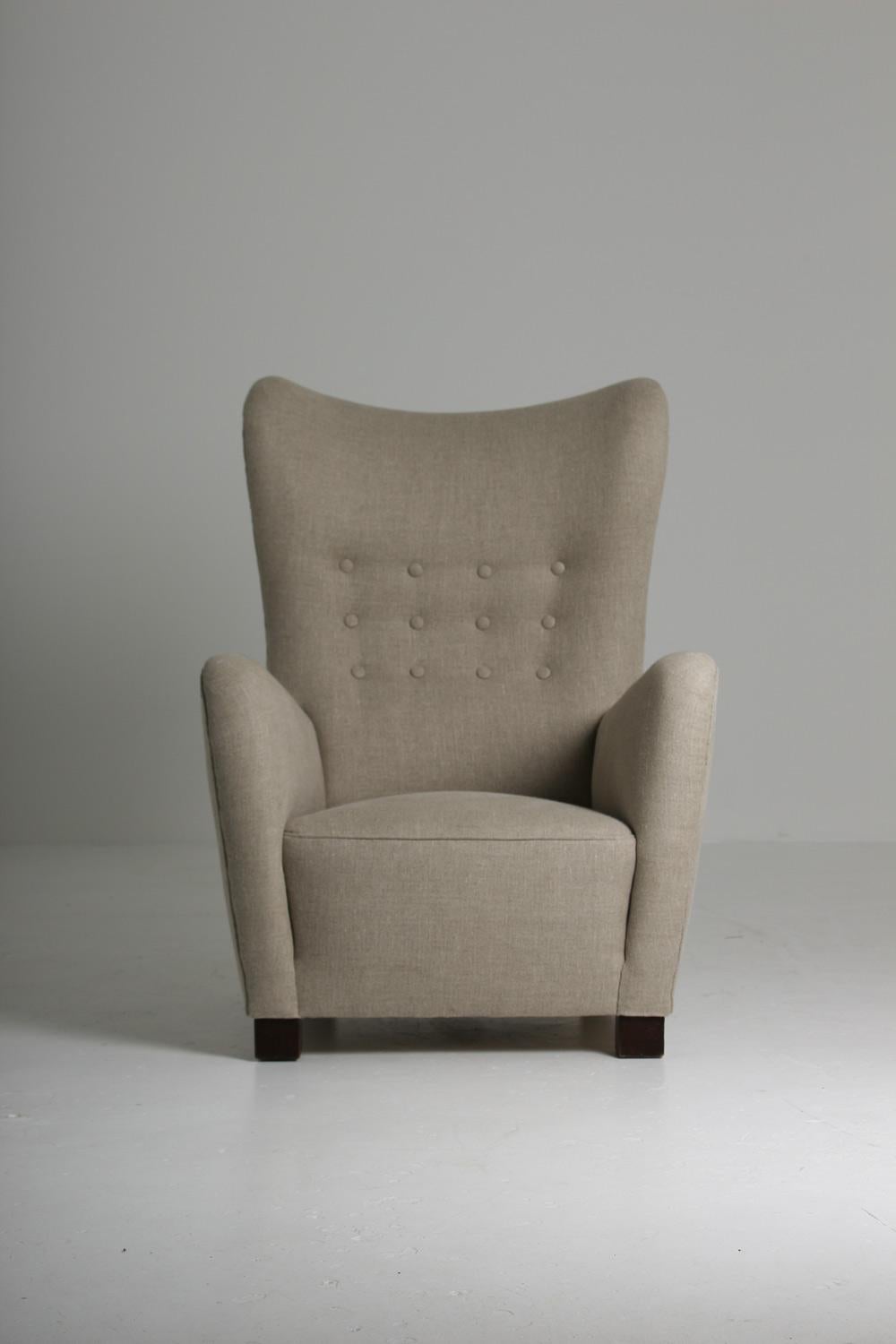 Impressive as much as its elegant with its silhouette formed wingbacks and striking solid angular armrests. Produced by Fritz Hansen in 1946 this 1672 Lounge chair, has been fully restored and reupholstered in fine weave linen of the highest