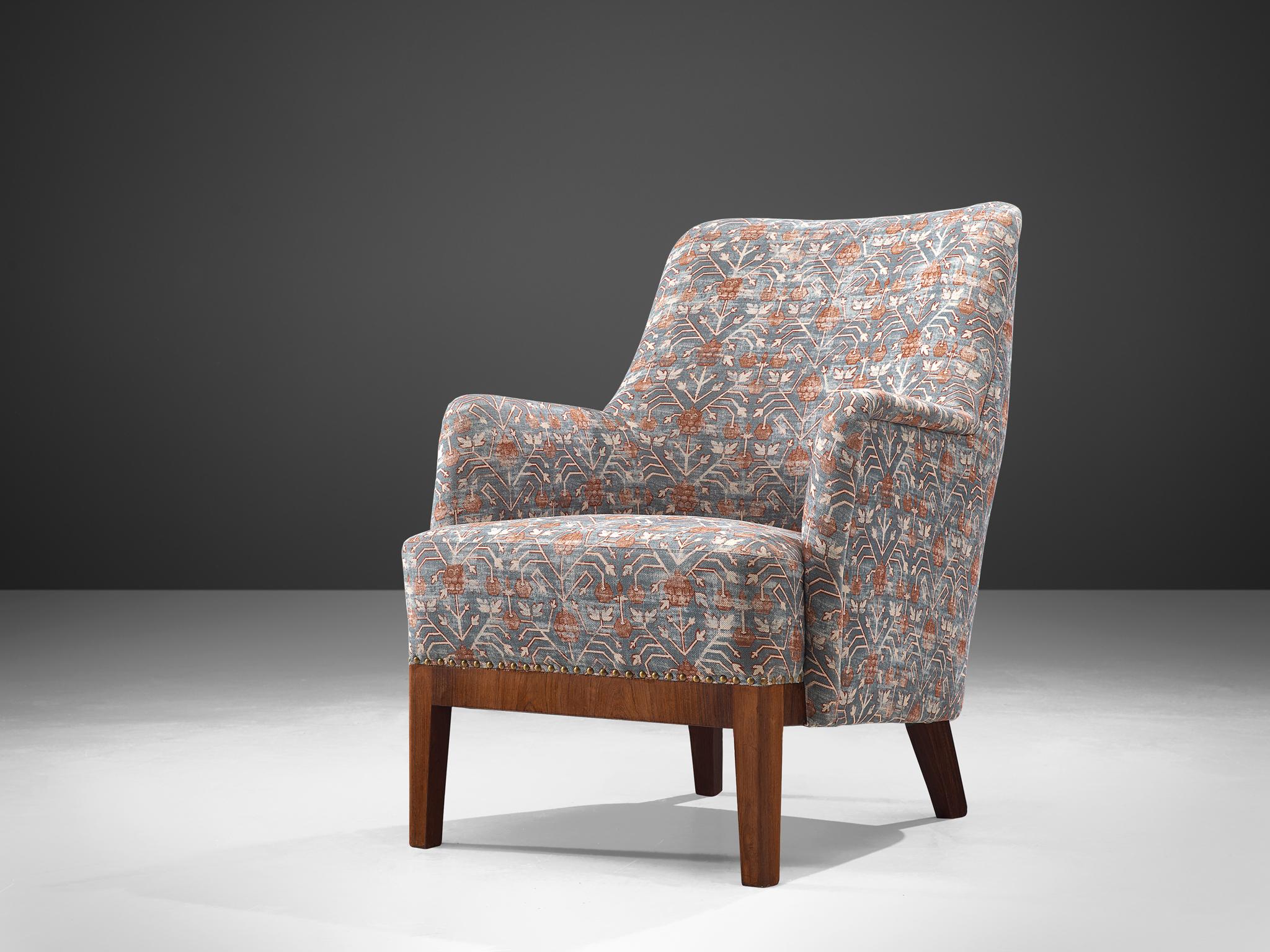 Armchair, fabric and rosewood, Denmark, 1960s.
This classic highback armchair show refined Danish craftsmanship and aesthetics. The backs feature a slightly tilted back and comfortable upholstered seating and back, as can be expected from Danish