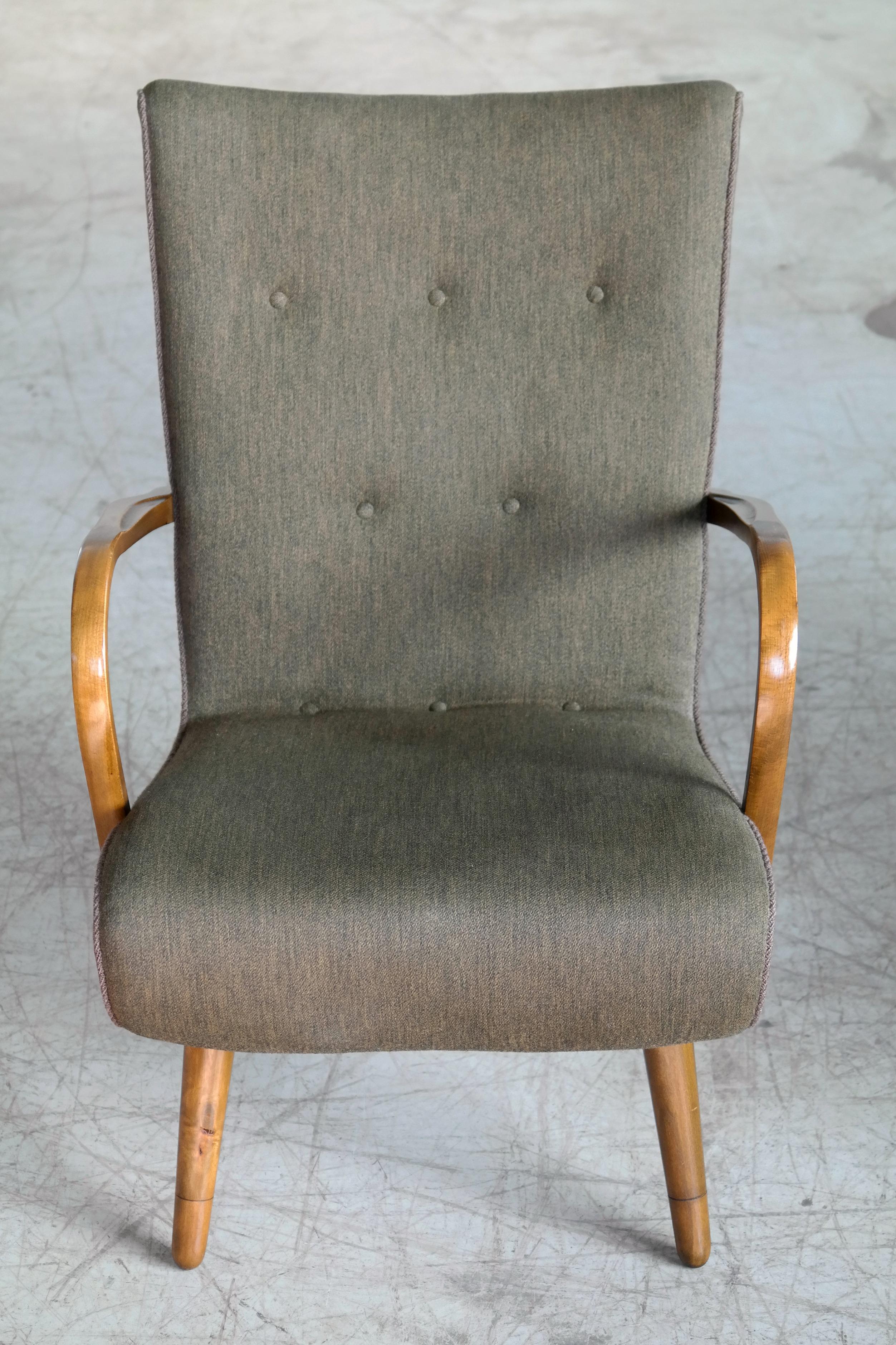 Unusual and very beautiful sculptural lounge chair with curved dark brown armrests in stained beech wood made by unknown Danish maker in the 1950s. These chairs are found from time to time in Denmark and are clearly of Danish origin but the style in
