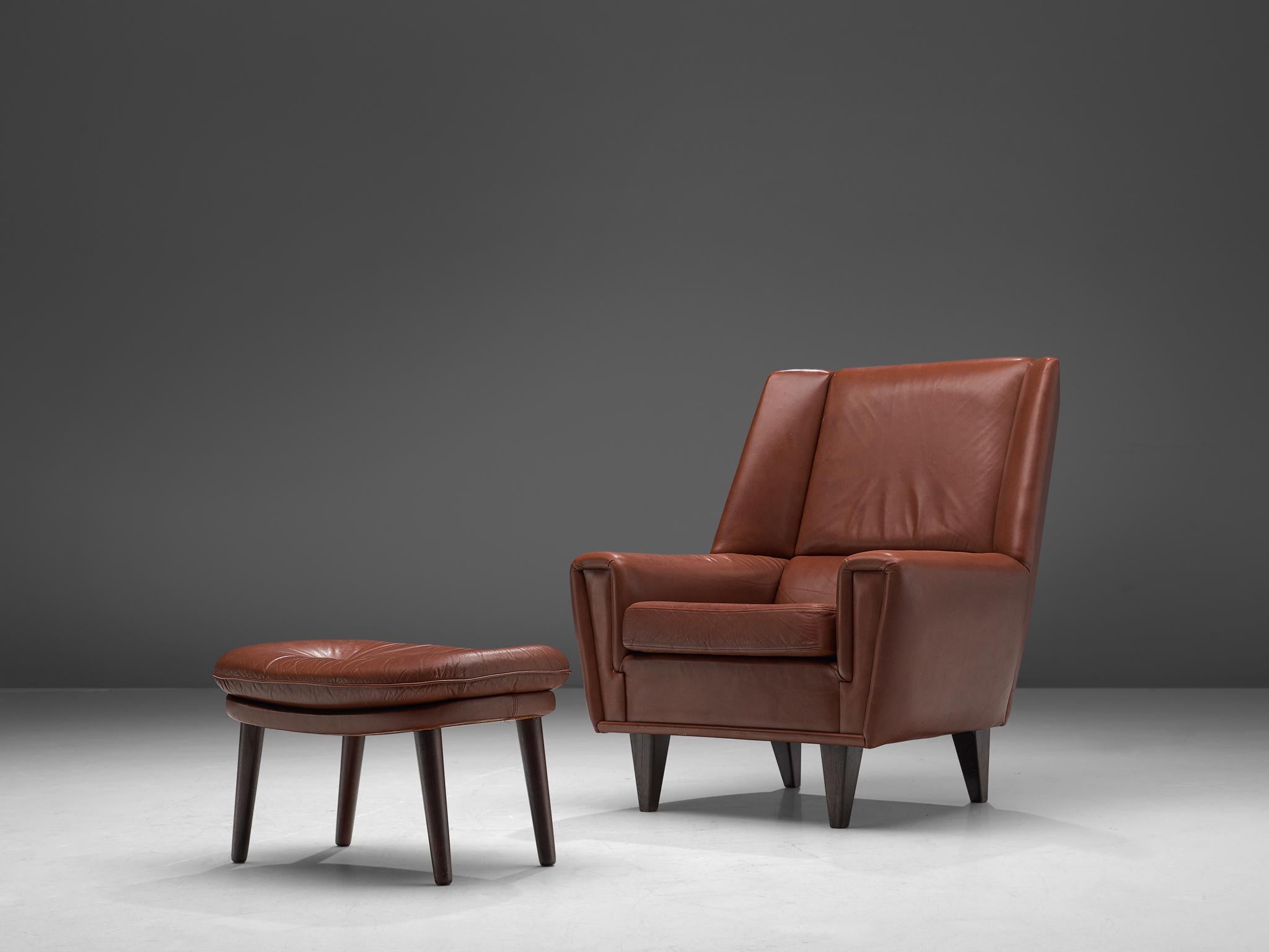 Danish cabinetmaker, lounge chair with ottoman, in brown leather and oak, Denmark, circa 1960.

This chair with ottoman is made to reach an ultimate level of comfort as can clearly be recognized in the design. This Danish chair features