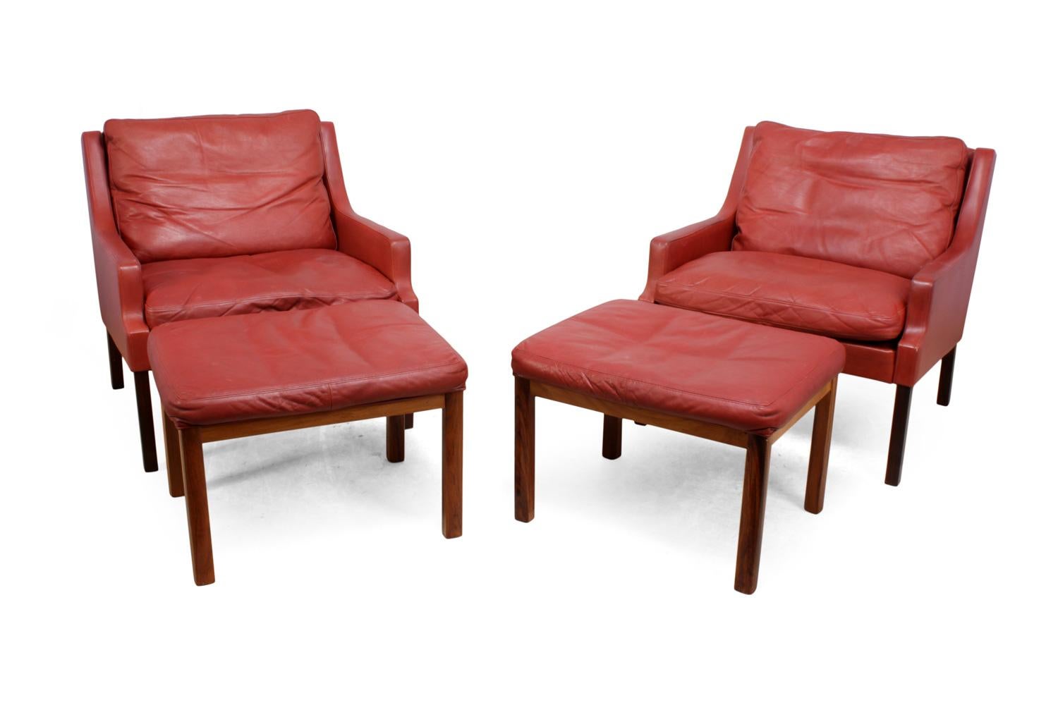 Danish lounge chairs in red leather with stools.
A pair of Danish lounge chairs and stools with rosewood legs and red leather upholstery and down filled cushions designed by Rud Thygesen and Johnny Sørensen. Manufactured by Vejen Polster