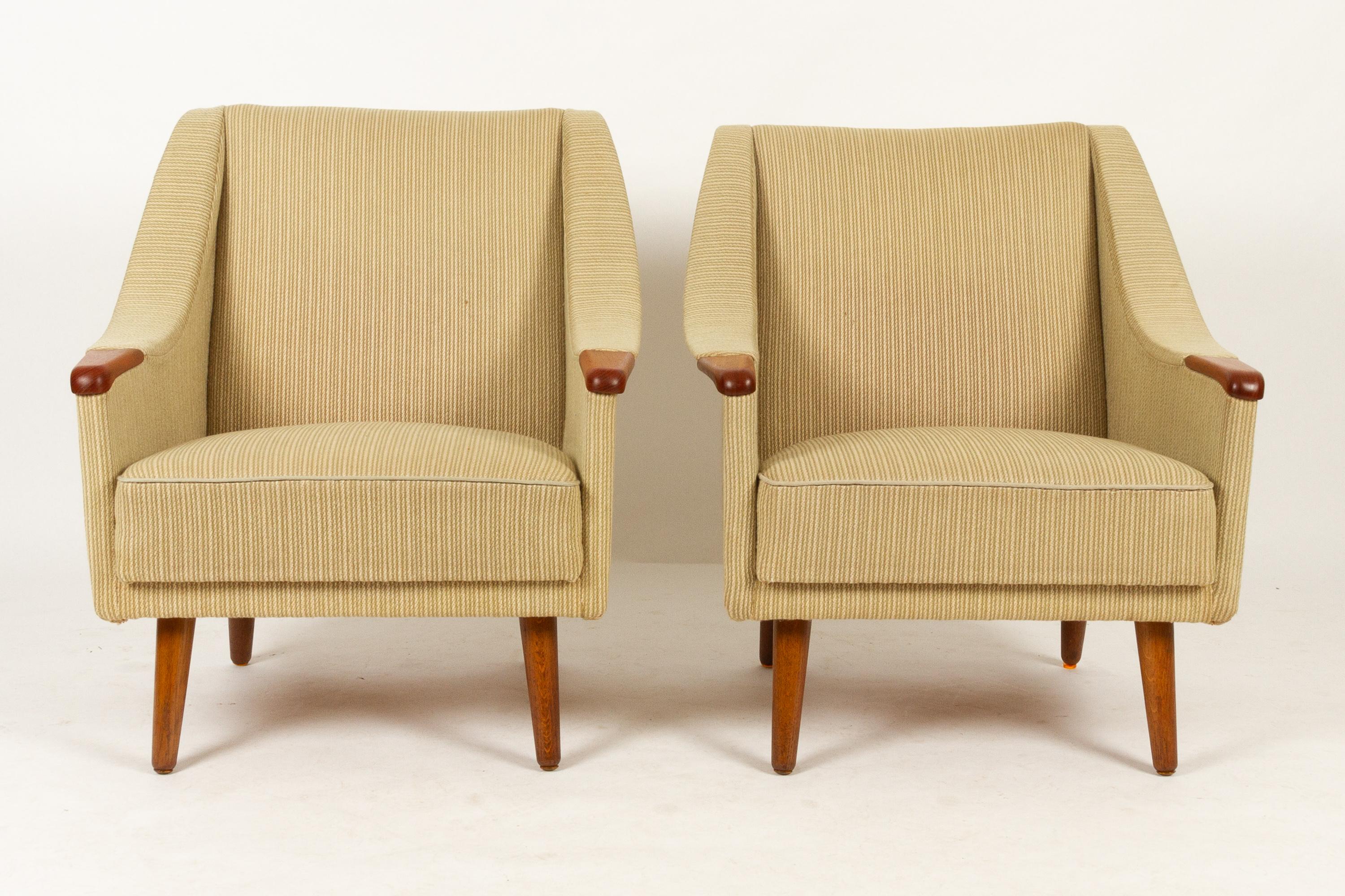 Danish lounge chairs with teak nails 1960s set of 2
Pair of period typical lounge chairs made in Denmark in the 1960s. Long curved sweeping armrests with solid teak nails. Original light colored striped fabric with green and beige notes. Standing