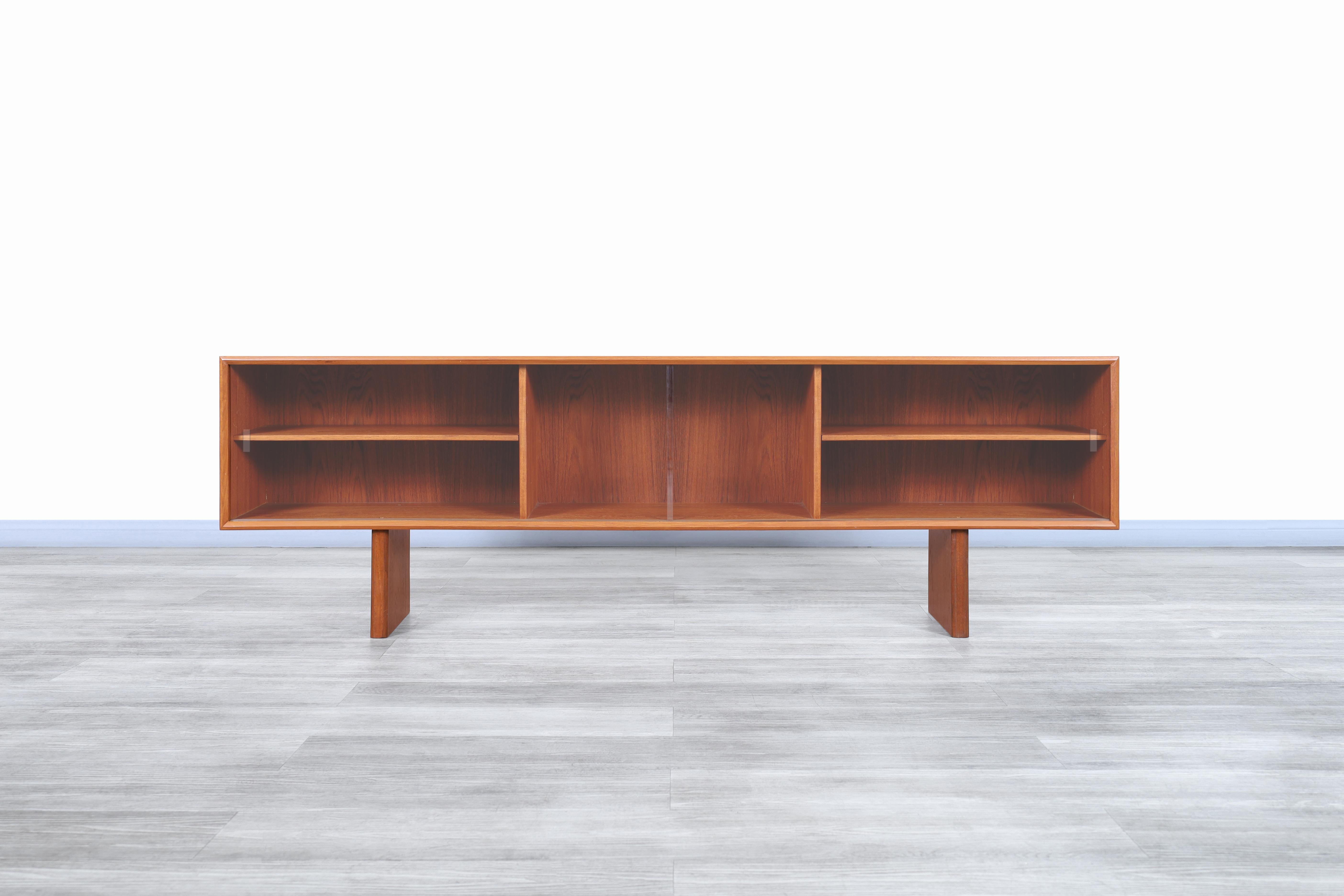 Wonderful Danish low profile teak bookcase / credenza manufactured by Faarup Møbelfabrik in Denmark, circa 1960s. This bookcase has a minimalist but highly functional design, where the teak wood stands out thanks to the grains of the wood that gives