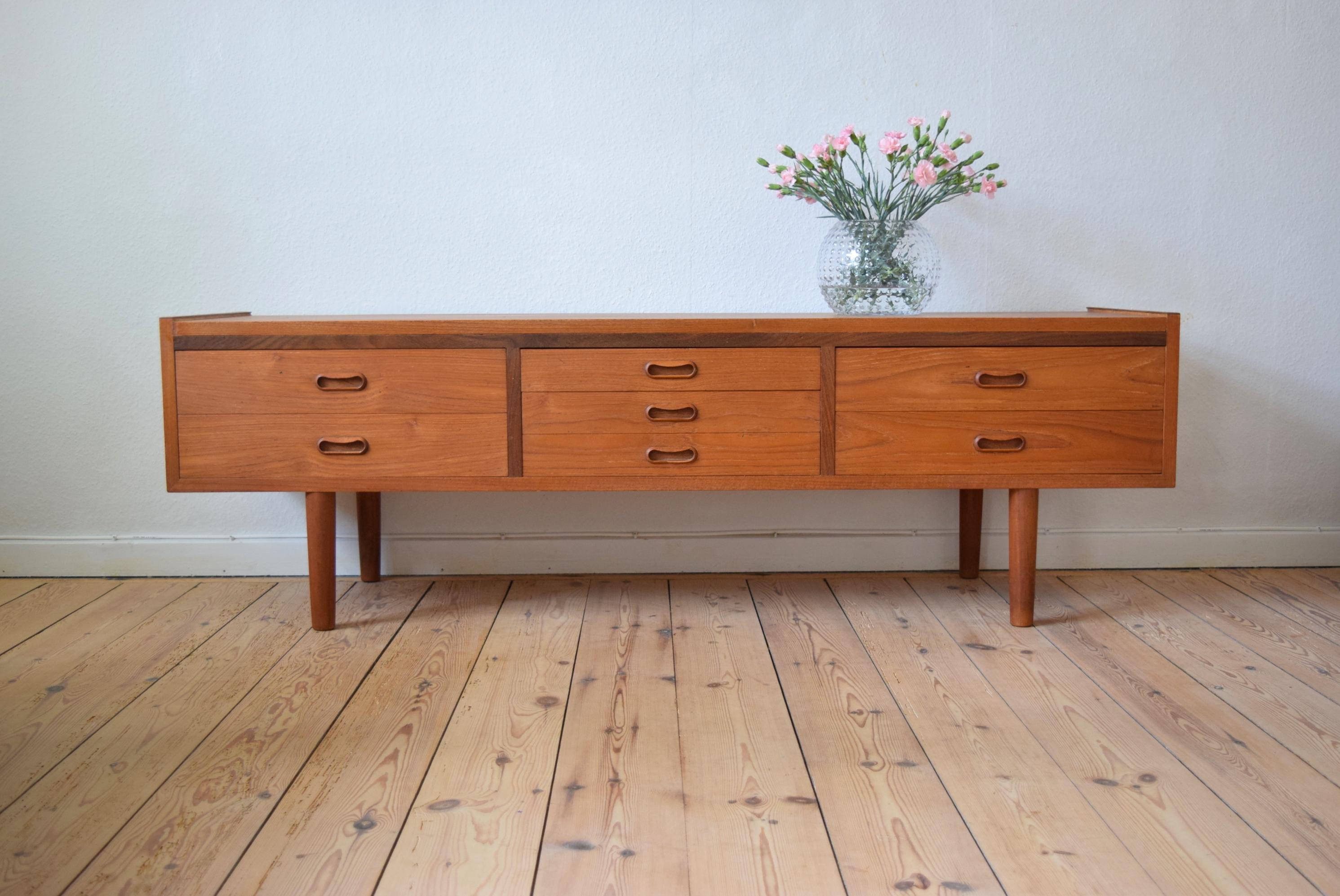 Elegant, low teak chest with seven drawers, circa 1960. This chest can be used as either a storage unit or as a platform for a TV of multimedia components. In good condition with few marks.