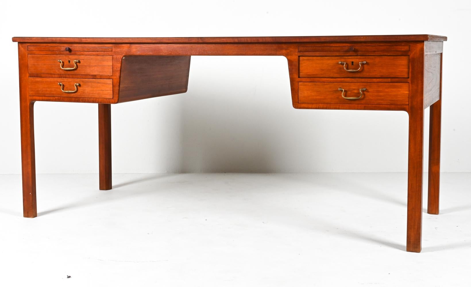 Rich mahogany takes on a glowing, satin-like luminescence in this breathtaking and rare writing desk by Ole Wanscher. The simple form is perfectly proportioned, with elegant squared legs supporting two symmetrical pairs of dovetailed drawers, each