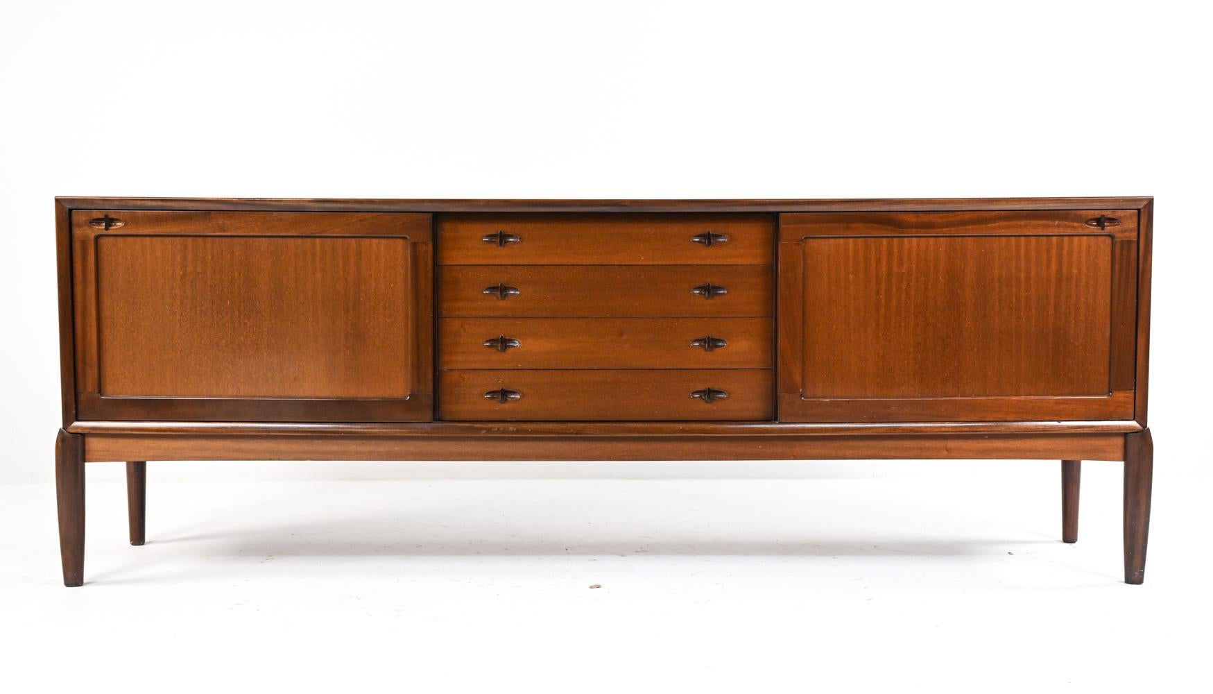 A beautiful and rare sideboard or credenza in fine mahogany veneer, with sculptural drawer handles and sliding doors. Designed by H.W. Klein for Bramin, c. 1950's.