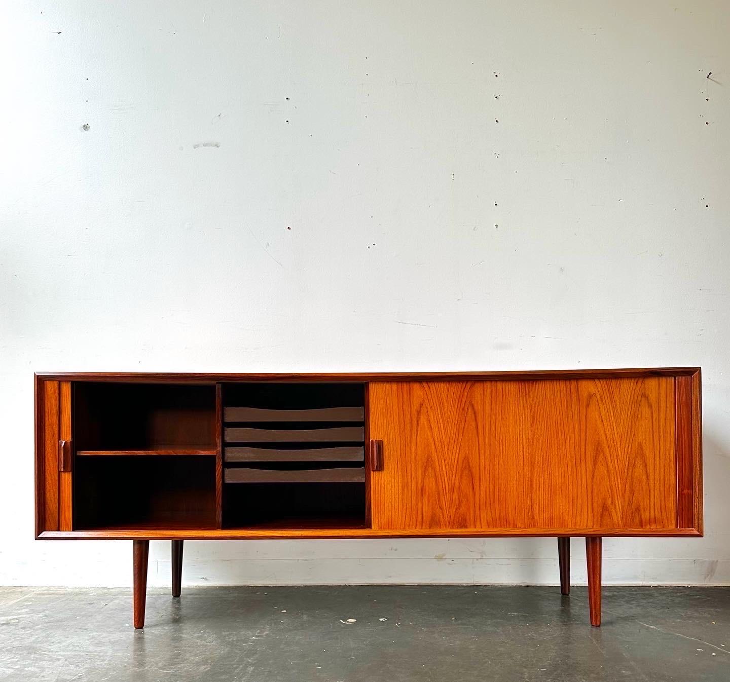 Rosewood credenza with tambour doors, made in Denmark circa 1960 by Svend Aage Larsen for Faarup.

Fantastic piece in great condition.  Sliding tambour doors that open up to sliding drawers and adjustable shelves.