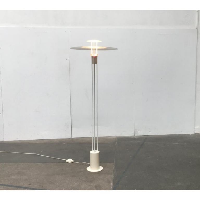 Rara lámpara de pie del fabricante danés Frandsen.

Un diseño especialmente delicado. Llama la atención el gran disco reflector. Debido a su diseño extremadamente plano, apenas se aprecia de perfil, lo que confiere a esta lámpara una elegancia