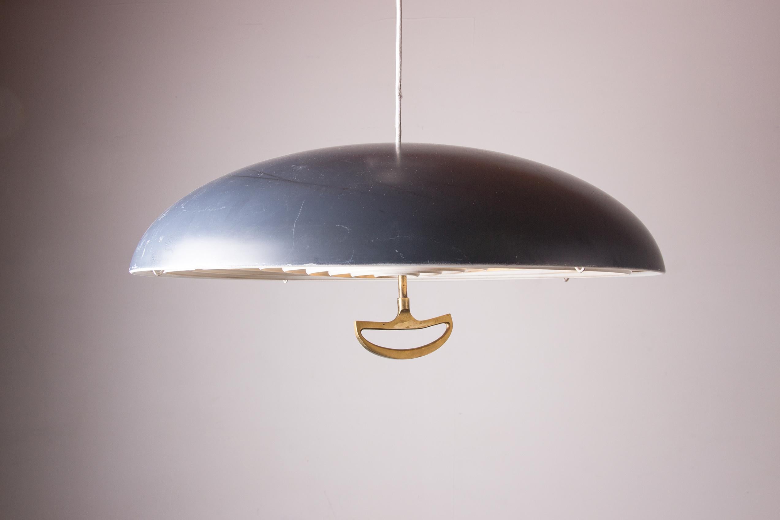 Superbe suspension scandinave. Une grande demi-sphère bleu-gris au-dessus d'une maille métallique tenue par une poignée en laiton. Rare, ce luminaire est d'une grande beauté.