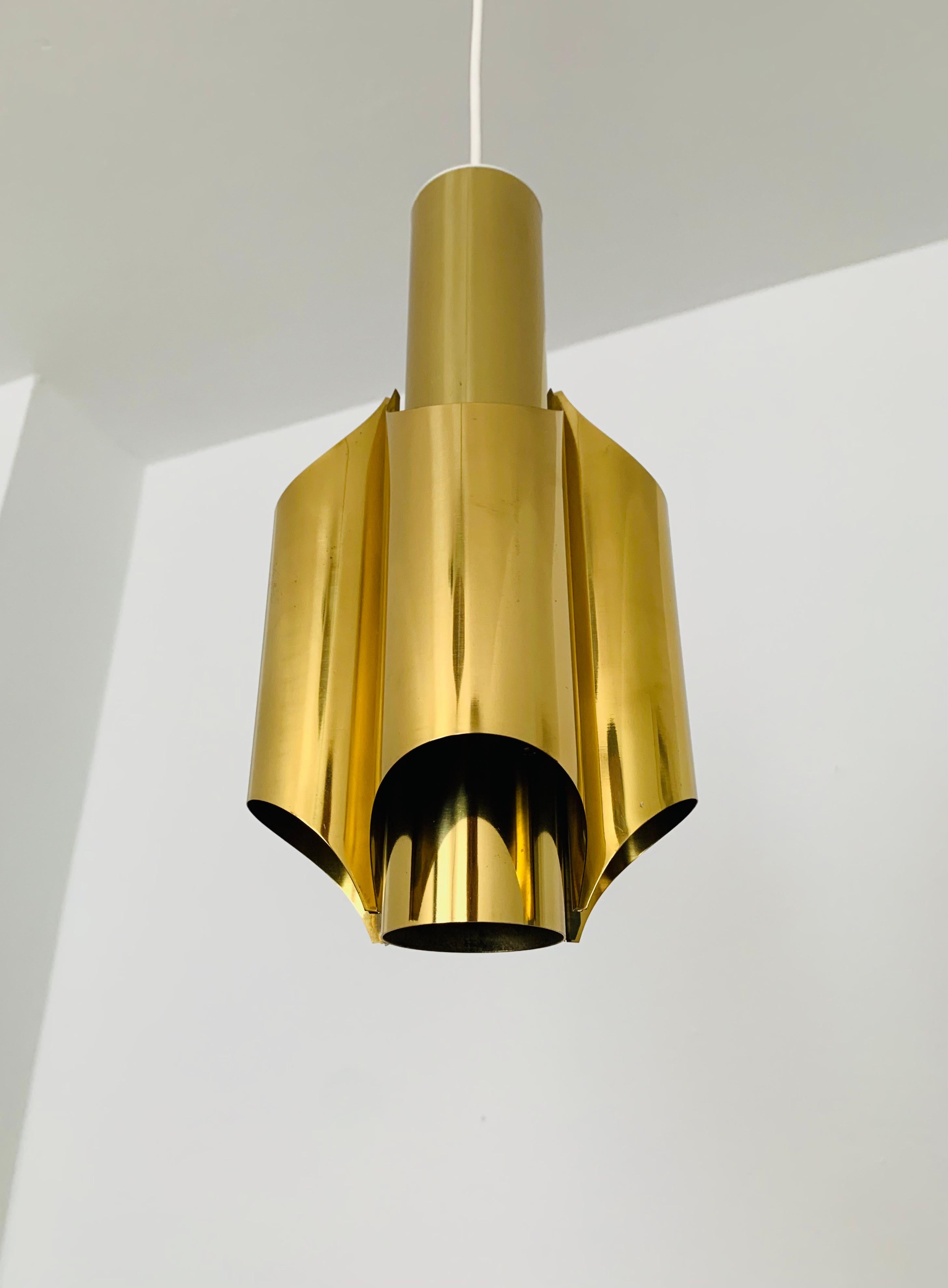 Bellissima lampada a sospensione dorata degli anni '60.
Il design e l'aspetto della lampada sono particolarmente belli.
La forma crea una luce meravigliosa.

Condizioni:

Condizioni vintage molto buone con lievi segni di usura dovuti