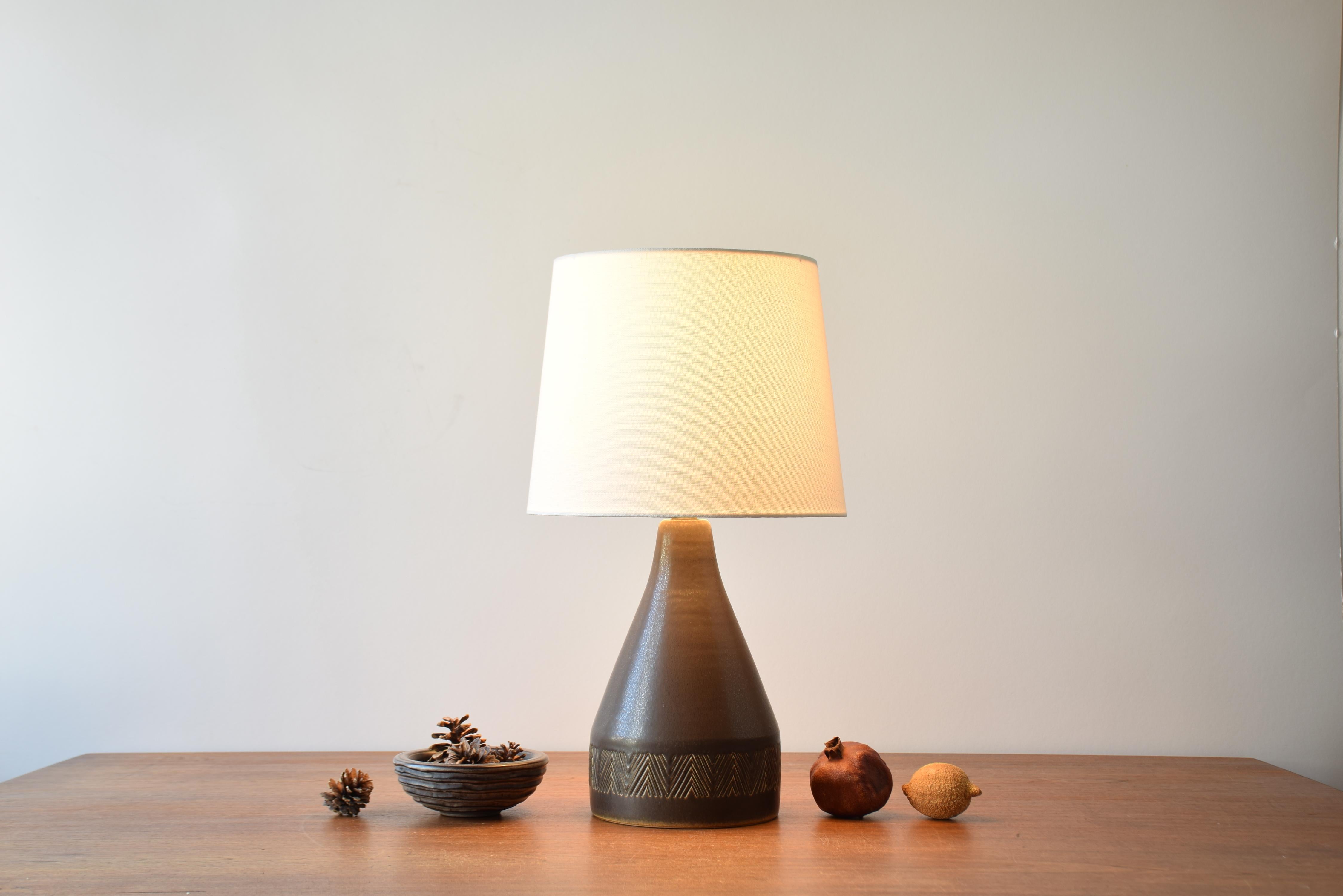 Danish Mid-century large table lamp from the Michael Andersen & Søn ceramic workshop on Bornholm. Made ca. 1950s to 1960s.

The lamp feautures a deep brown haresfur like glaze and has a simple yet stylish impressed zig zag decor around the