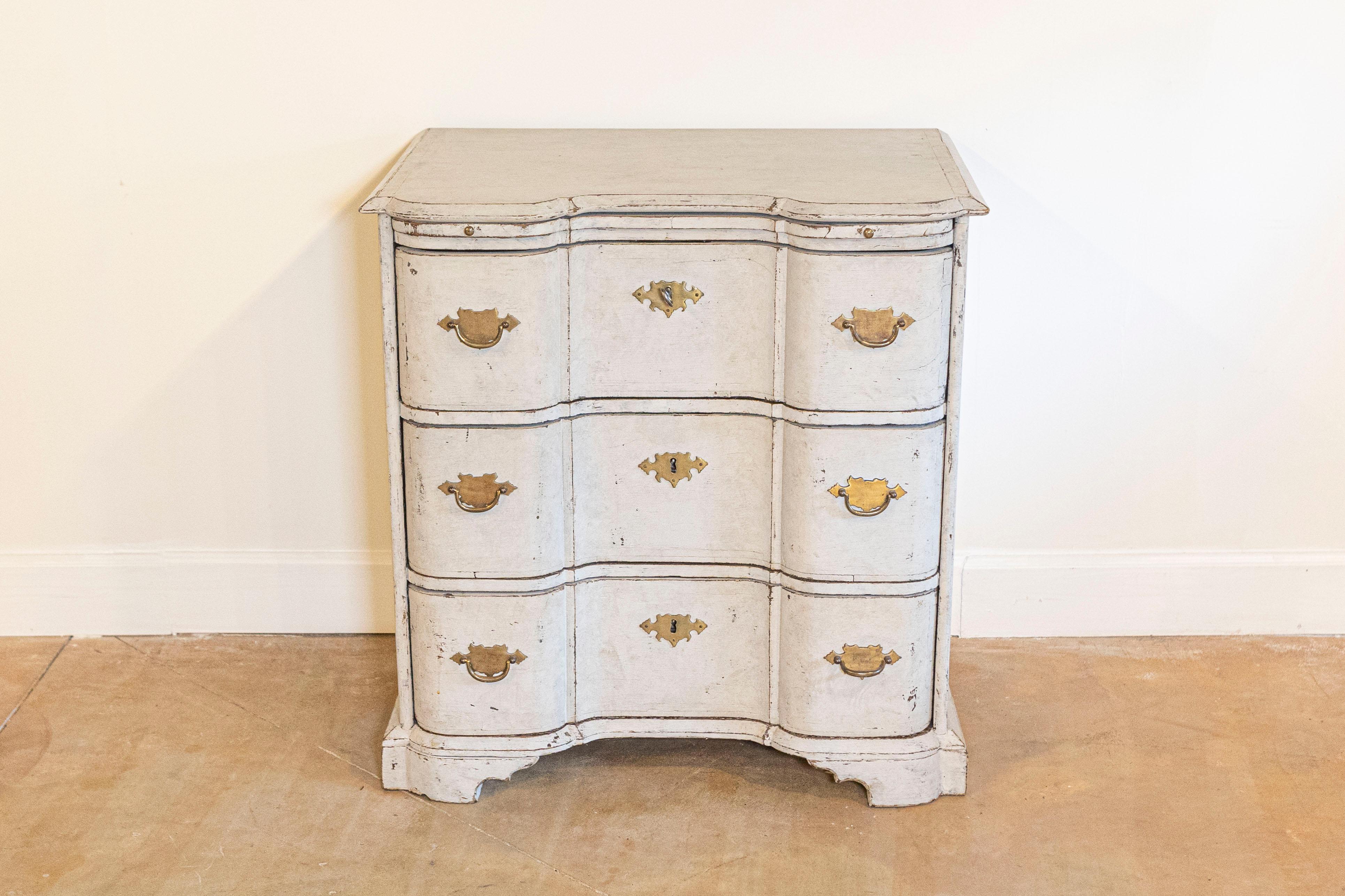 A Danish serpentine front three-drawer painted wood commode from the mid 18th century with pull-out shelf. This three-drawer commode was born in the 1760s in Denmark. Featuring a shaped top with beveled edges, a very thin pull-out drawer sits
