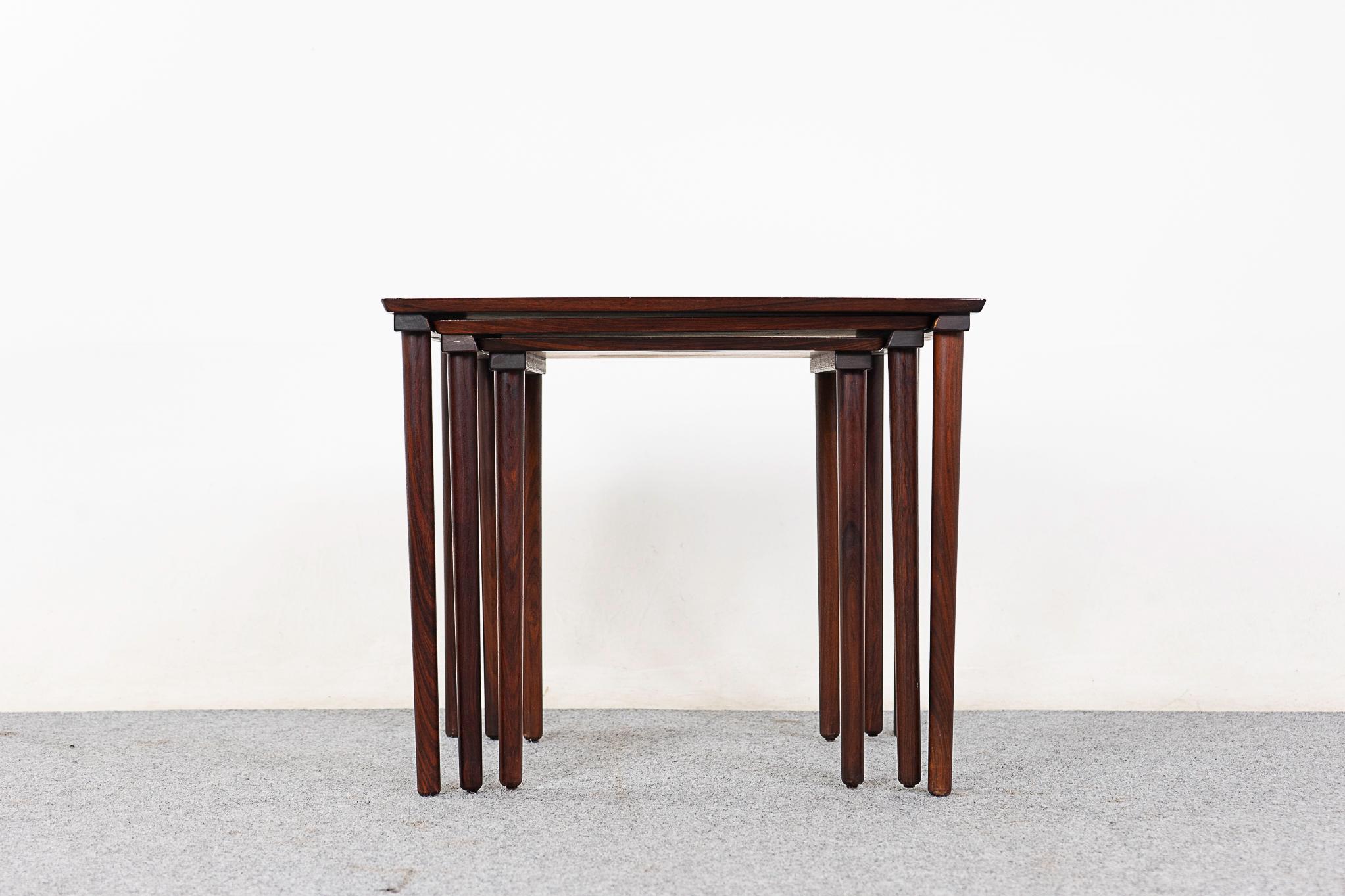 Rosewood nesting tables by Mobelintarsia, circa 1960's. Book matched veneer and solid wood trim, use individually or nest them together to save space. Mobelintarsia makers' mark intact.

Unrestored item, some marks consistent with age.