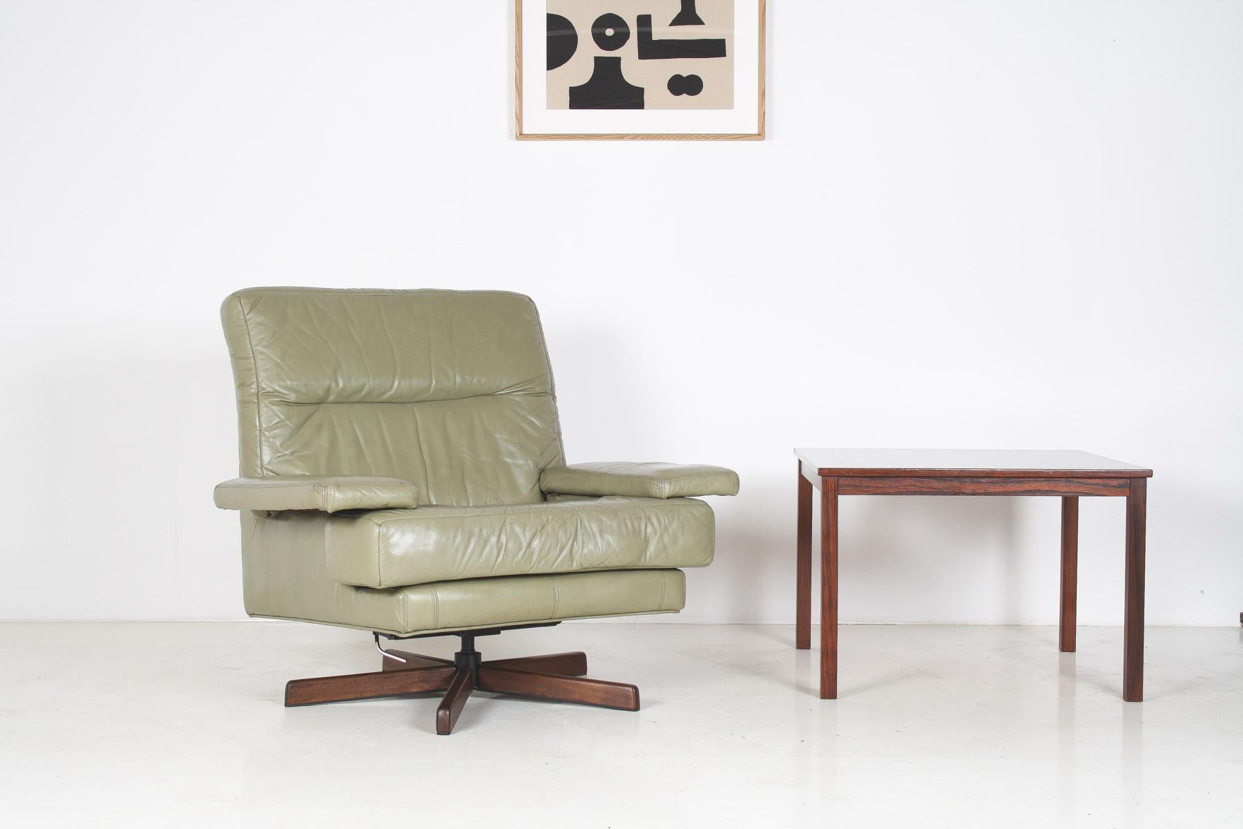 A stylish mid-century swivel chair from the 1960s/70s, expertly crafted in Norway by the renowned manufacturer Ring Mekanikk. Finished in a beautiful sage green leather, this chair features a robust metal base complemented by wood accents.
This