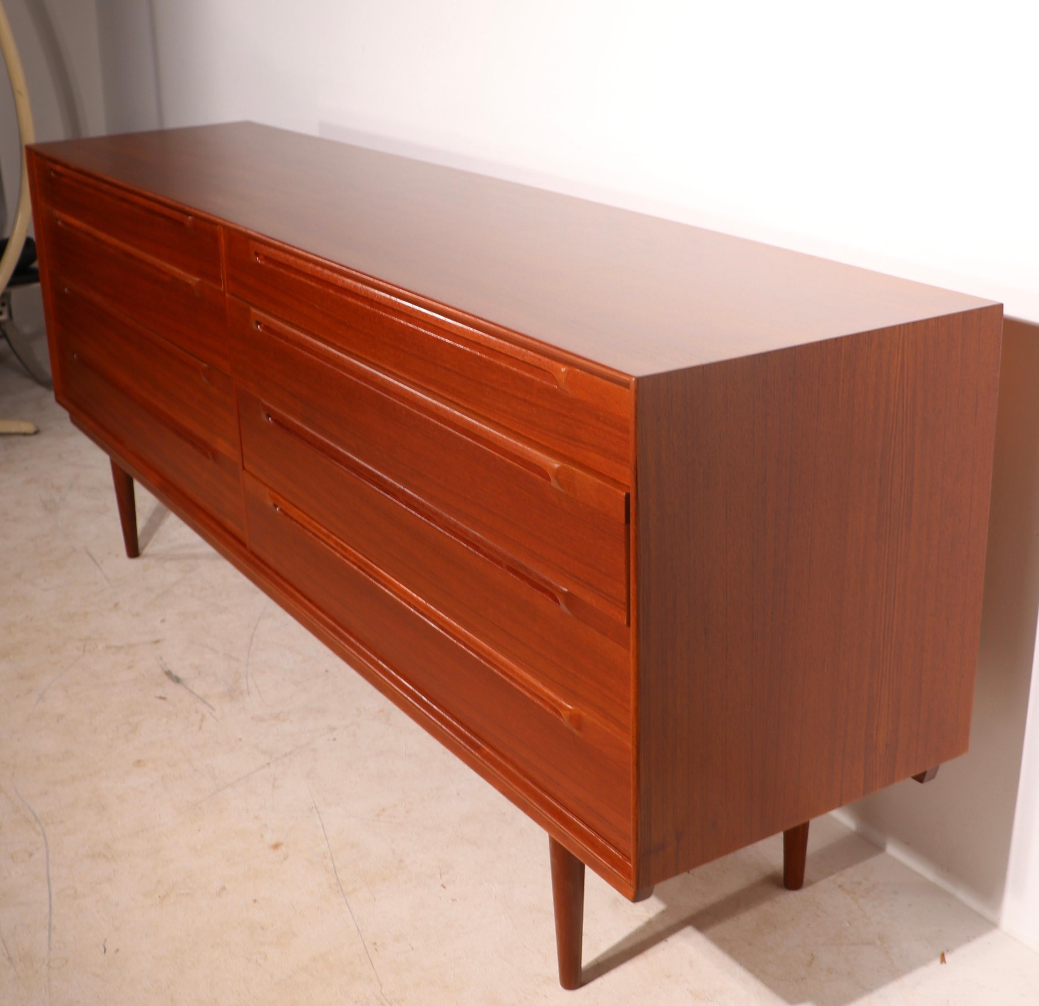 Incredible Danish Modern double dresser in exceptional refinished condition. This example features eight drawers, two banks of four drawers each, it is constructed of solid teak, and has been newly professionally refinished to perfection. Design