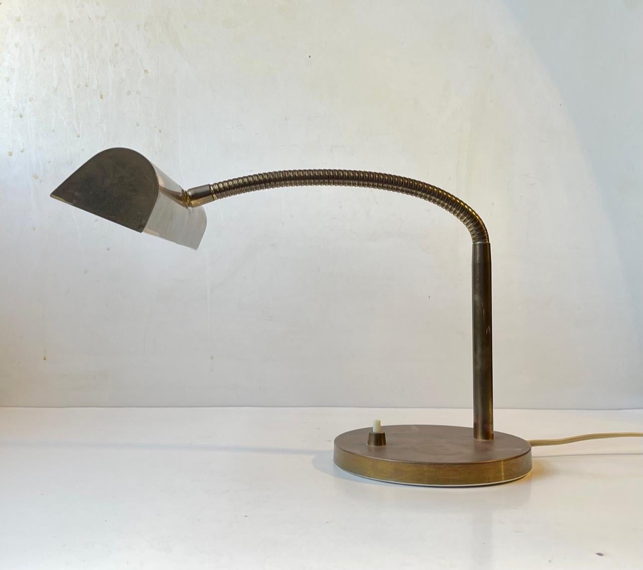 This midcentury danish bankers or librarians table light features two light-sources. Its made entirely out of brass and has a multi-adjustable gooseneck that allows you to direct the light in any direction. It was manufactured by E. S. Horn in