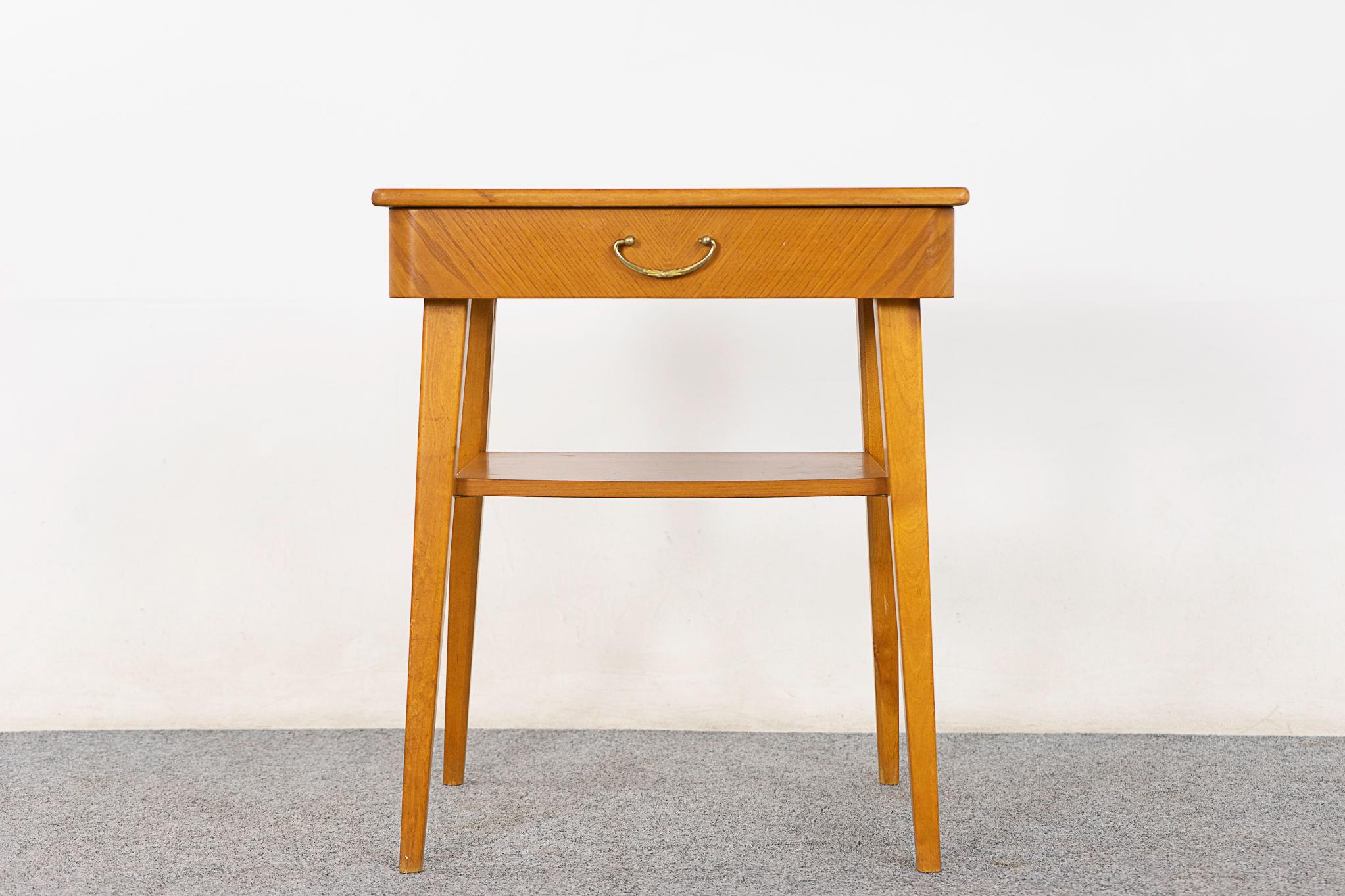 Beech Danish bedside table, circa 1960's. Beautifully veneered case and drawer face, slender tapered legs. Handy shelf and a dovetailed drawer with elegant metal handle. 

Please inquire for remote and international shipping.