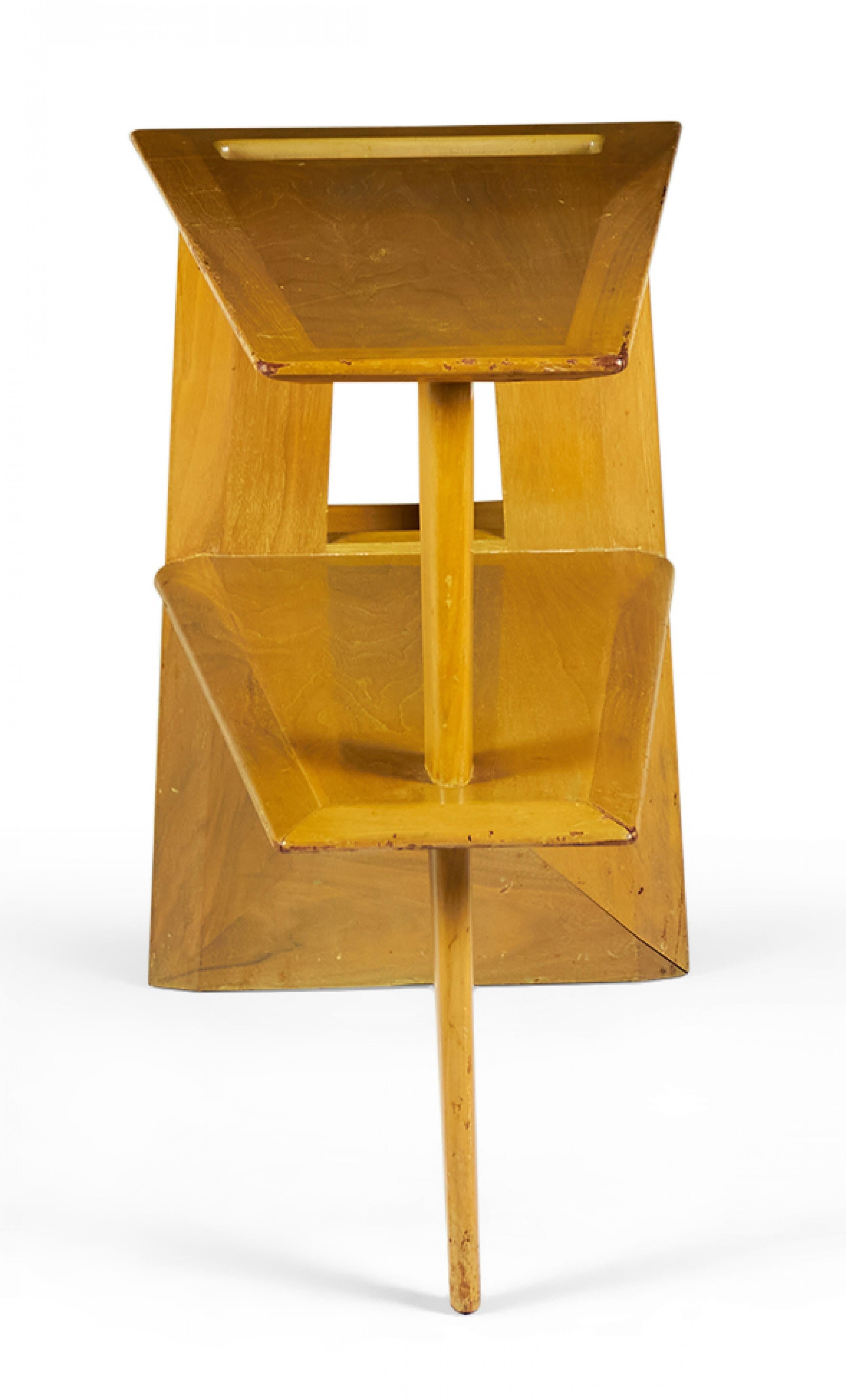 Mesa auxiliar danesa de mediados de siglo, de caoba rubia, con tablero en forma de cuña con un recorte rectangular y un estante inferior de forma similar, sostenido en el lado más delgado por una pata cónica que va desde la parte superior hasta el