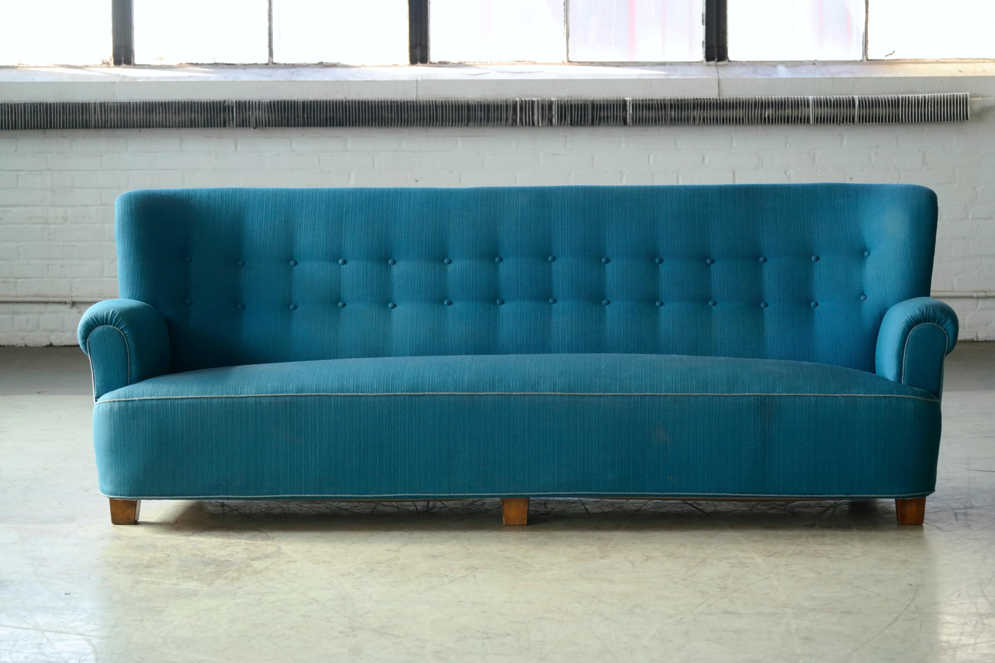 Impressive Danish four-seat sofa from the 1940s. Similar stance and proportions and seen in Viggo Boesens's voluptious designs but without his signature rounded armrests. These armrests combined with the solid square legs are more characteristic of