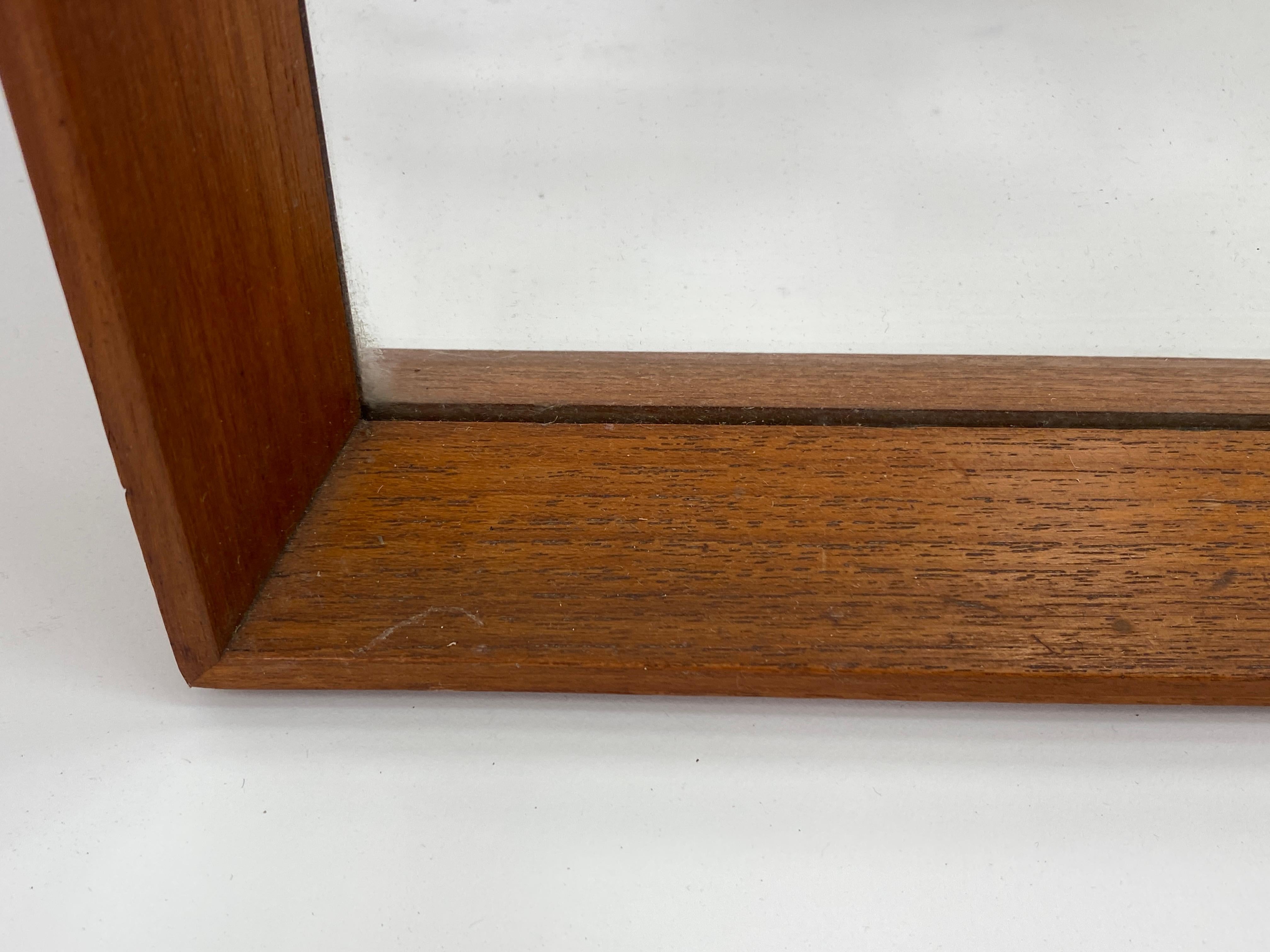 A stylish Danish mid-century wall mirror in teak, with Central Mobler / Bolighus label to back.