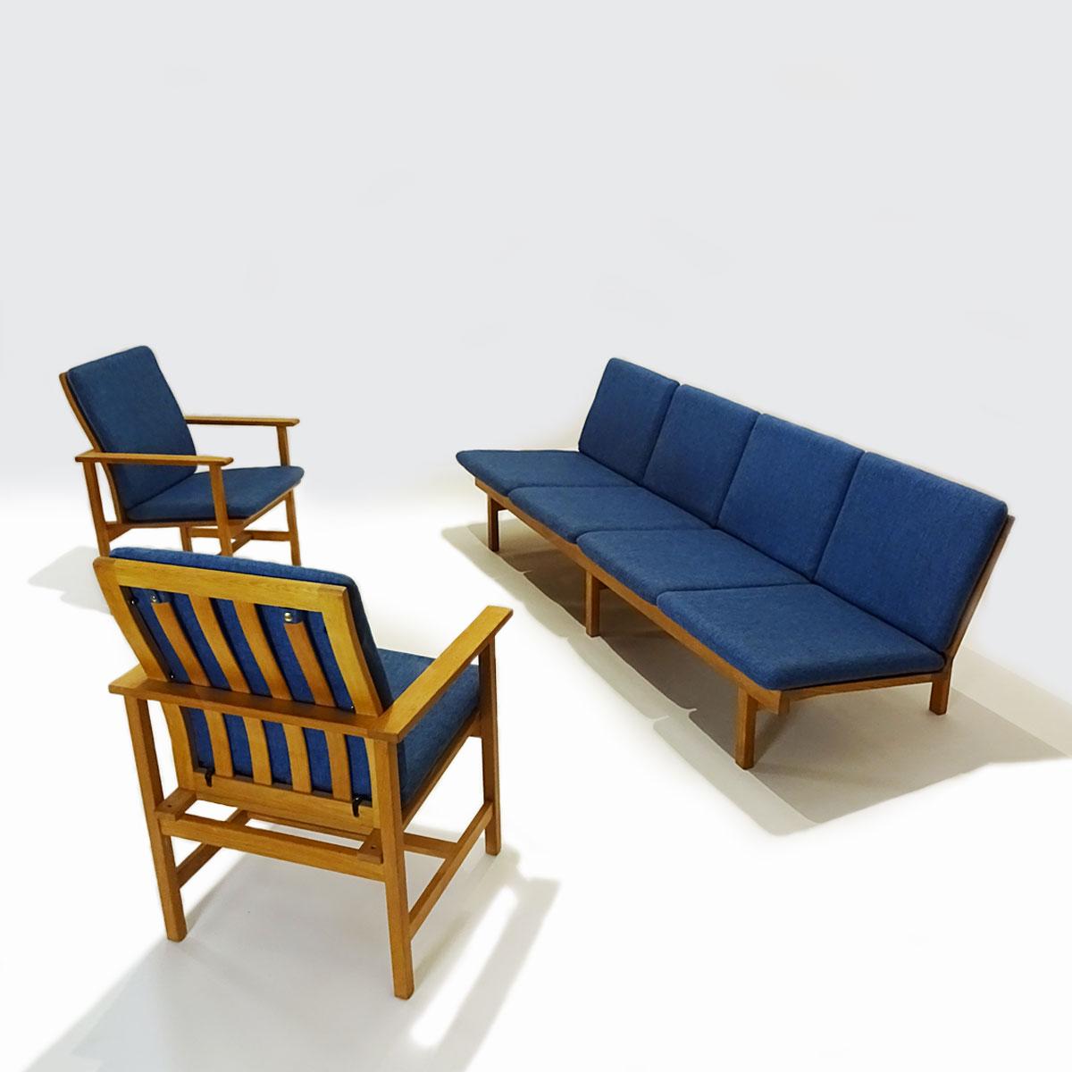 A Danish midcentury 1950s oak and blue fabric lounge set featuring a 4 seater model 2219 bench sofa and two 2257 armchairs by Børge Mogensen for Fredricia Stolefabrik. 

Designed and produced in the 1950s this set very much follows Mogensen’s