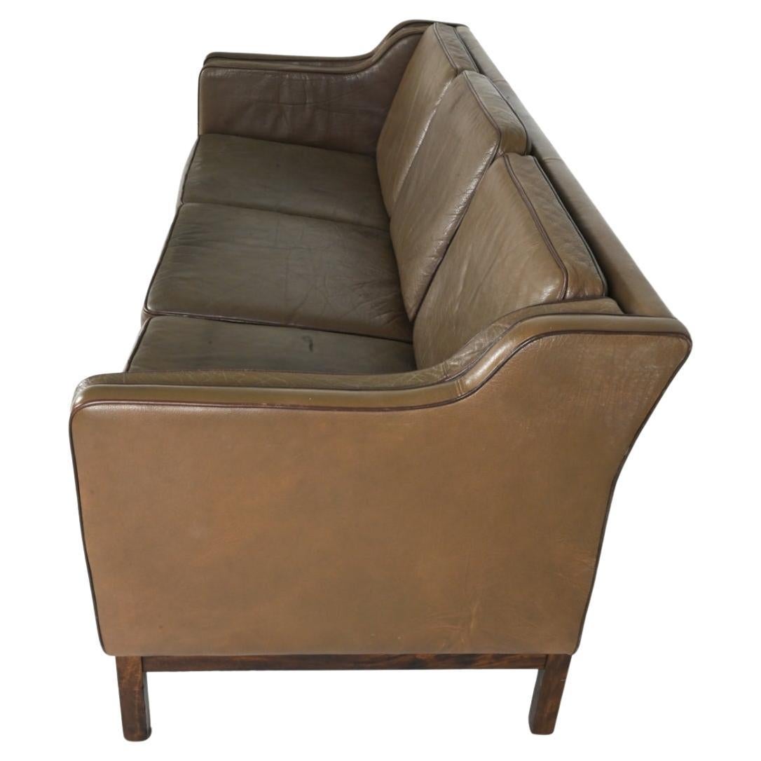 Luxuriöses Büffelledersofa mit dunkleren Paspelierungen von Mogens Hansen. Dieses Sofa zeichnet sich durch sanft abfallende Armlehnen mit einer strengen und raffinierten Silhouette aus. Er ist aus geschmeidigem Leder mit einer weichen,