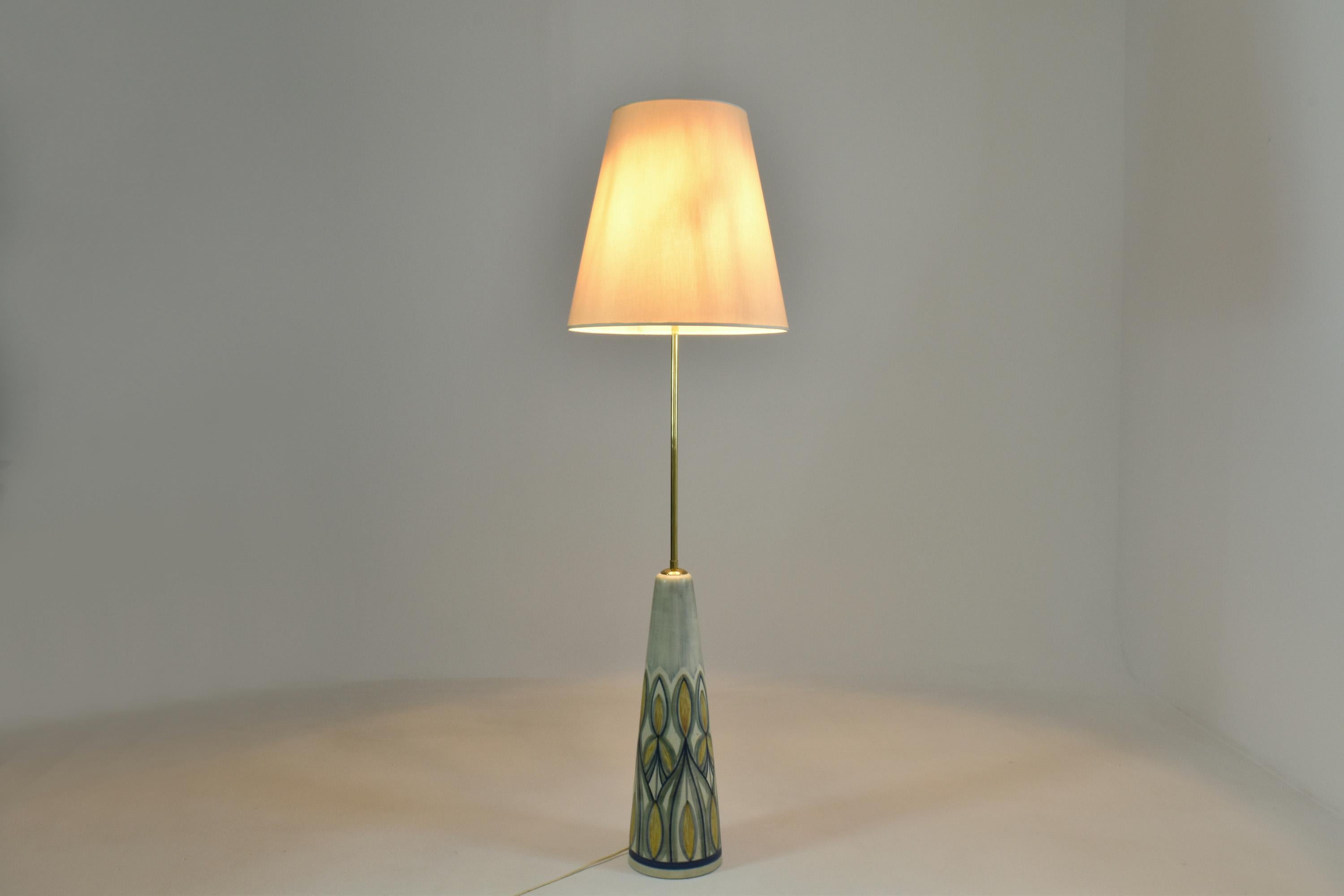A very big and beautiful 20th-century vintage hand-painted ceramic floor lamp manufactured by the Danish company Søholm Stentøj in 1965. The conical base was painted by artist Rigmor Nielsen in blue, yellow, cream, and pastel tones. 
The stem is in