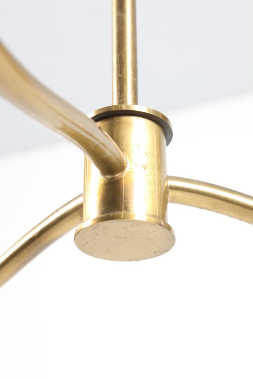 Chandelier in brass. Three branches with shades of brass. Made designed and made in Denmark, 1950s.