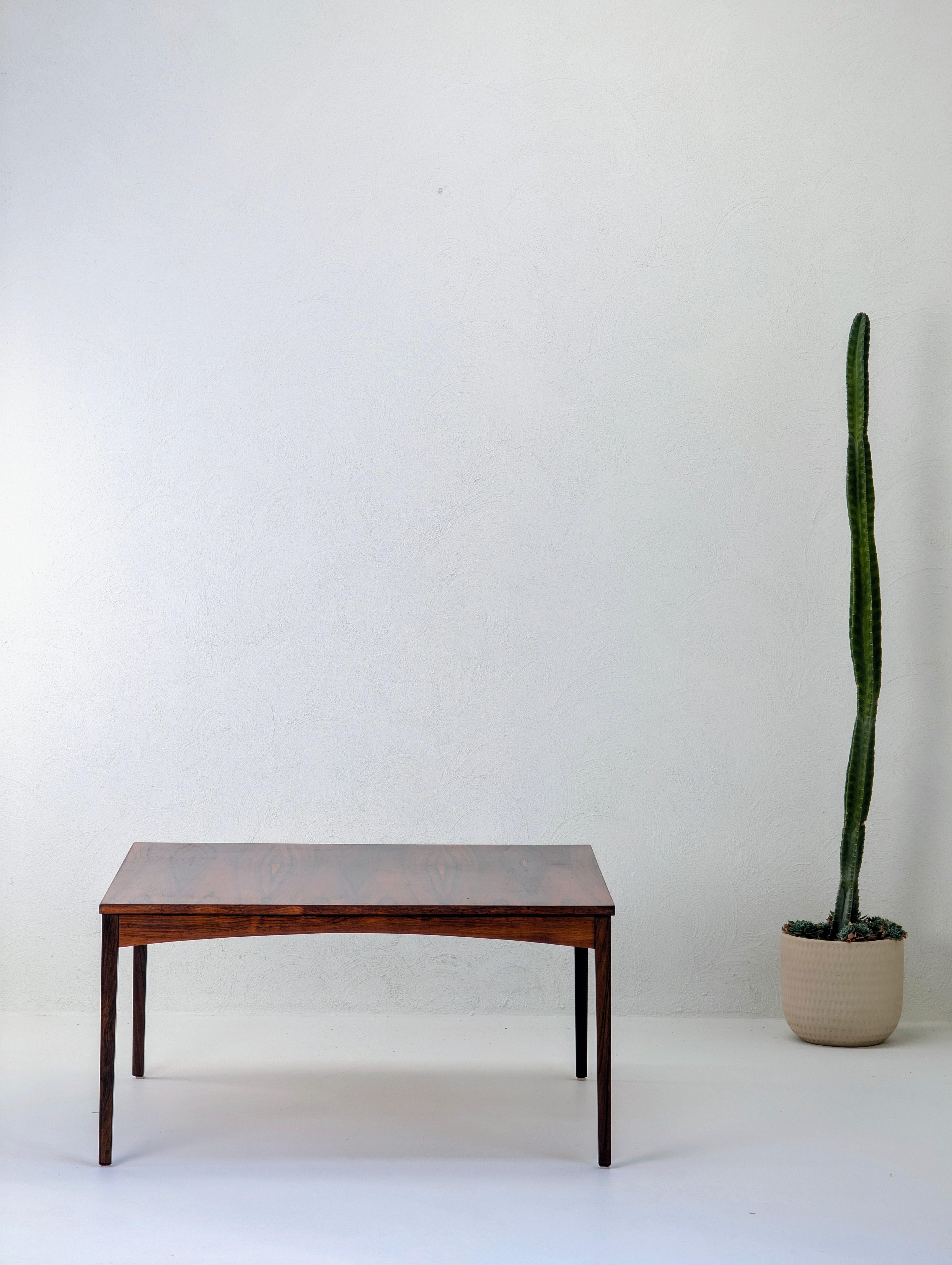 Una mesa de centro danesa de mediados de siglo realmente excepcional, definida por su espectacular uso del palisandro de Brasil (Dalbergia nigra), una de las maderas más codiciadas e históricamente significativas de la historia del diseño moderno.