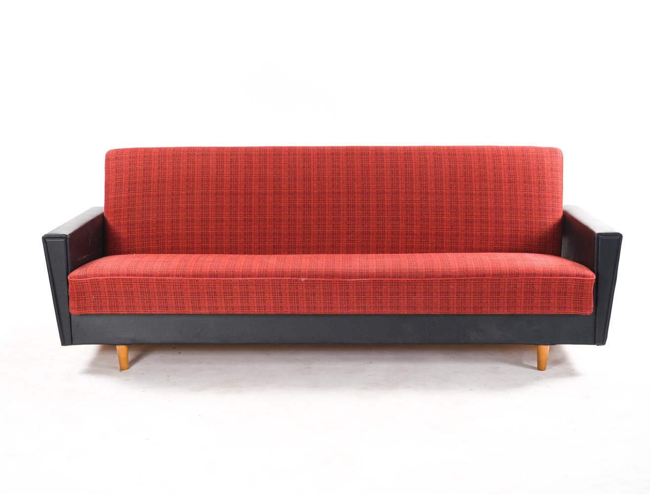 A Danish midcentury daybed or sofa with fabric and faux leather upholstery. An attractive juxtaposition of bold red and black faux leather which gives this piece a stylish edge to it.
