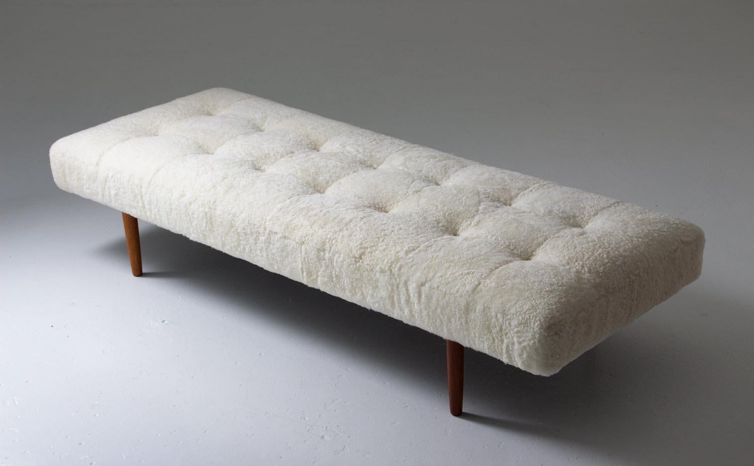 Danish 1950s daybed with round teak legs, reupholstered in sheepskin patchwork with leather buttons. 

Condition: Excellent.