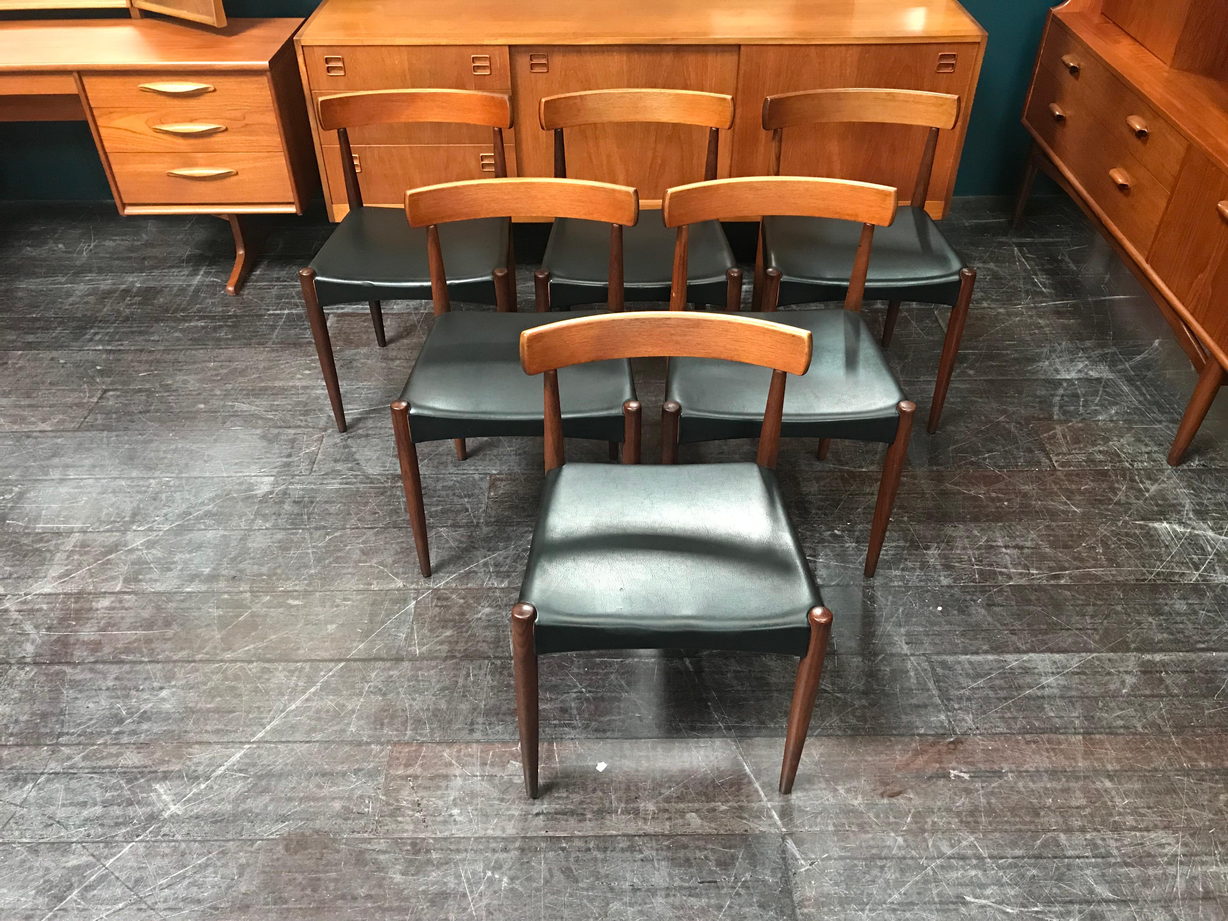 A stunning set of six Hovmand Olsen chairs with black vinyl seat pads. These elegant dining chairs were designed for the Danish manufacturer Mogens Kold and are made from teak.

Danish furniture designer Arne Hovmand-Olsen was born in Kirkeby Sogn