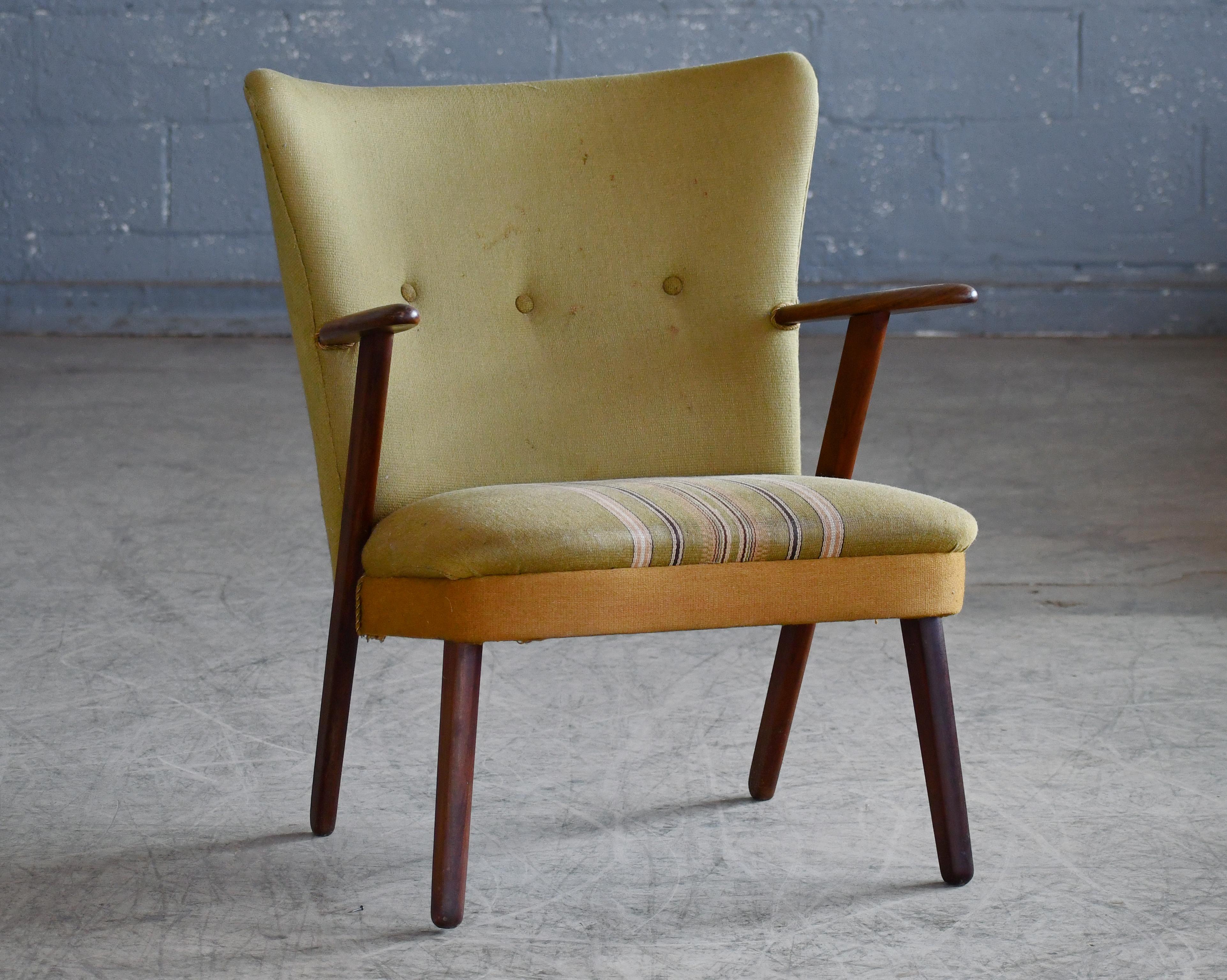 Very cool Danish mid-century armchair in teak covered in wool and very representative of the easy chairs of the time designed by such icons as Arne Vodder and Hans Wegner. Made by Erhardsen &Andersen in the 1950's. Frame is built into the seat and