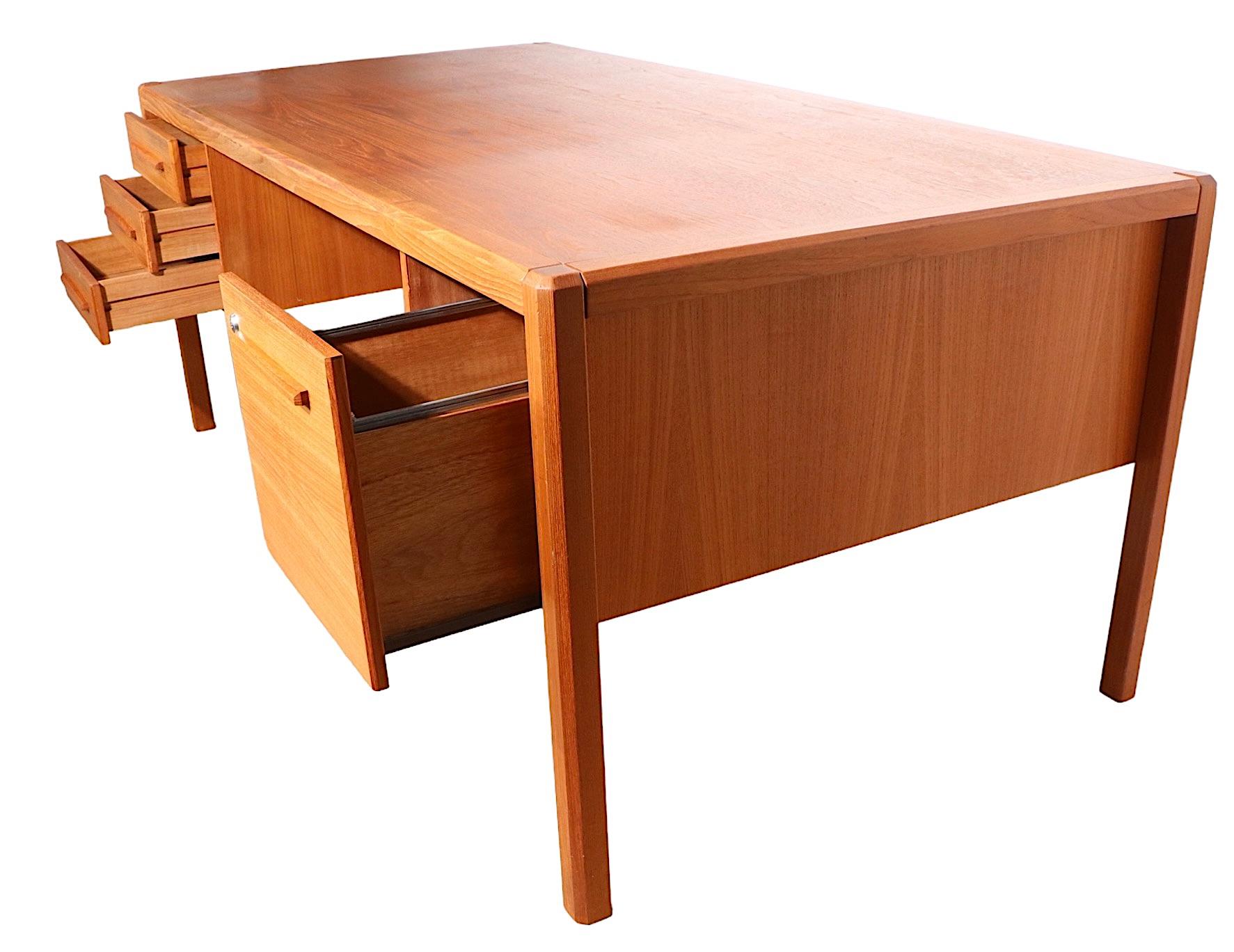 Exceptional large executive style Danish, Mid-Century Modern teak desk. The desk features two banks of drawers , one being a deep file drawer, with an opposing bookcase front. Large enough to function in a commercial environment, but not too large