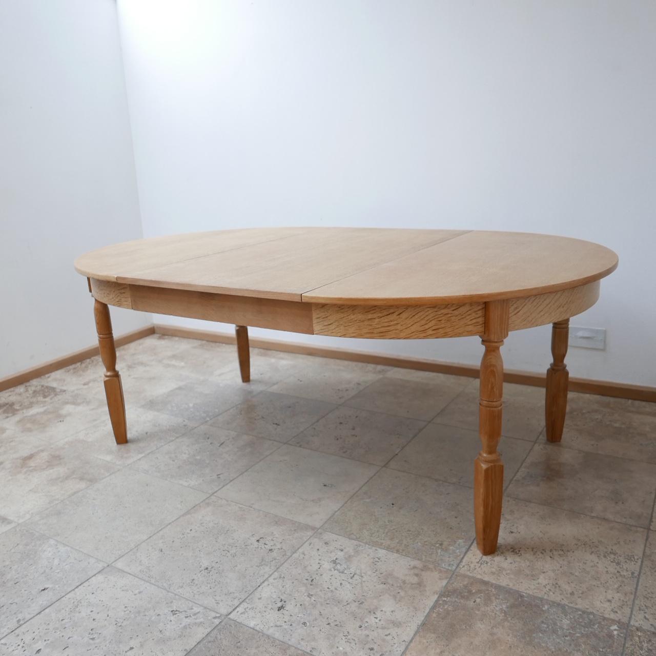 A Danish circular extenable mid-century dining table. 

One additional leaf extends the table if needed. 

Believed to be oak. 

Denmark, c1960s. 

The main table is in very good condition, the leaf has some small nicks of veneer loss but