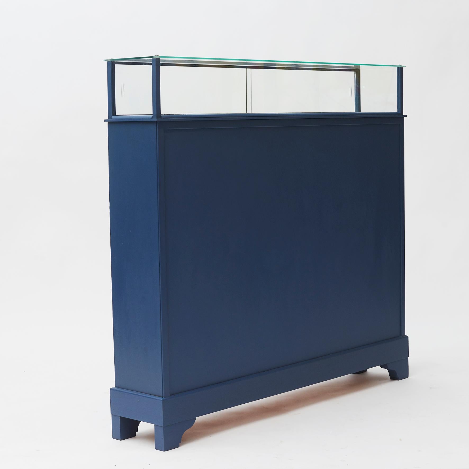 Freestanding bookcase with glass showcase on top. 
Pair of sliding doors from shelf side.
Denmark, circa 1950.

Repainted in a beautiful petrol blue color.