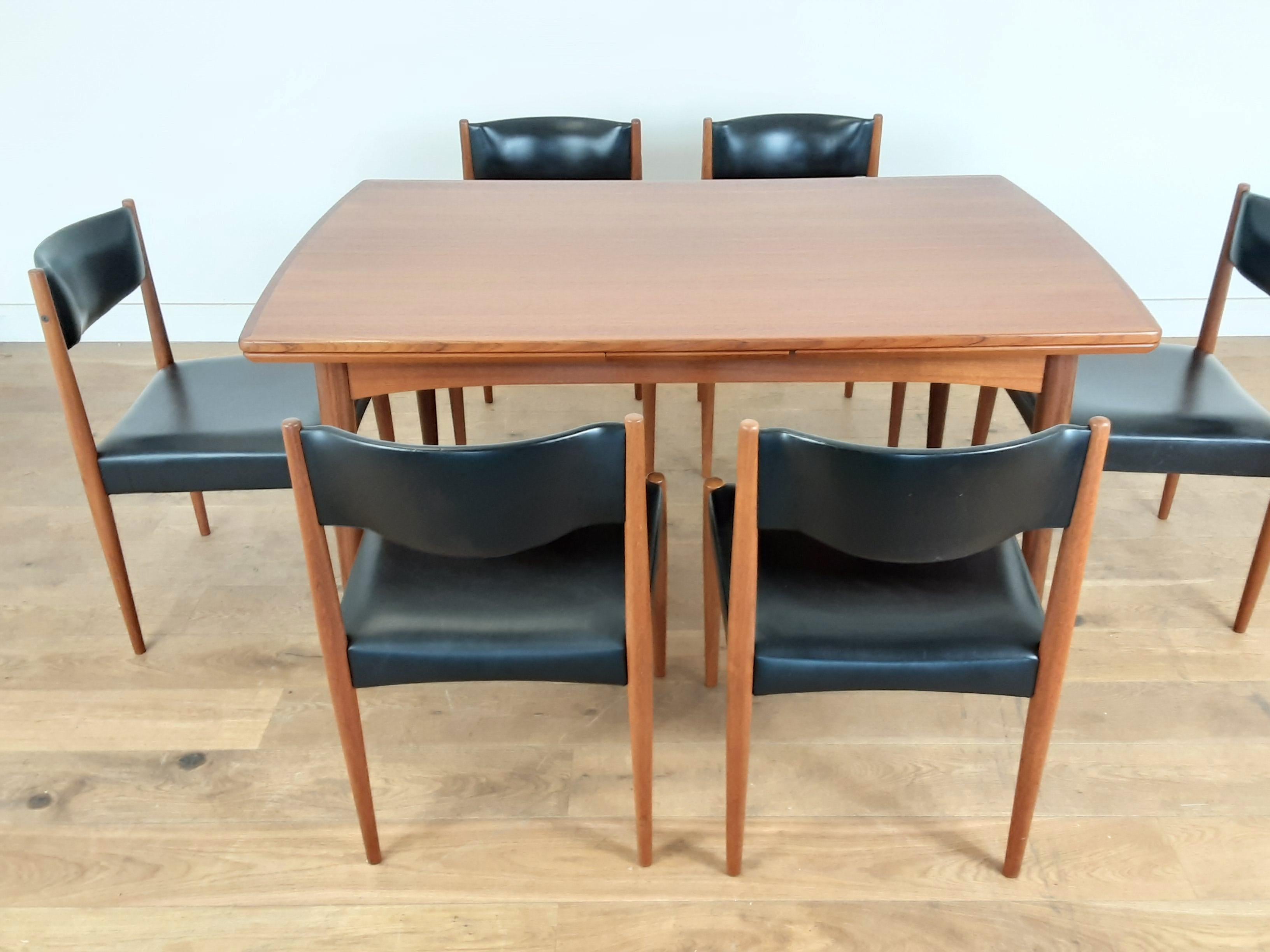 Midcentury dining table and chairs.
extendable dining table in golden teak wood with a set of six turned teak wood chairs upholstered in a black vinyl.
Danish, circa 1960.
Measures: Table 257 cm fully extended, each leaf is 55 cm, 72.5 cm H, 146