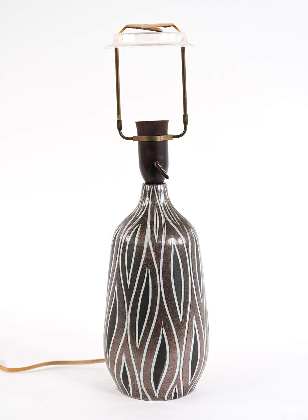 This unique and rare pottery lamp comes to you from the Rødovre studio of noted Danish ceramist H. Rudolf Petersen, whose work is often characterized by bold and graphic lines, mastery of the sgraffito technique, and African-inspired earth tones.