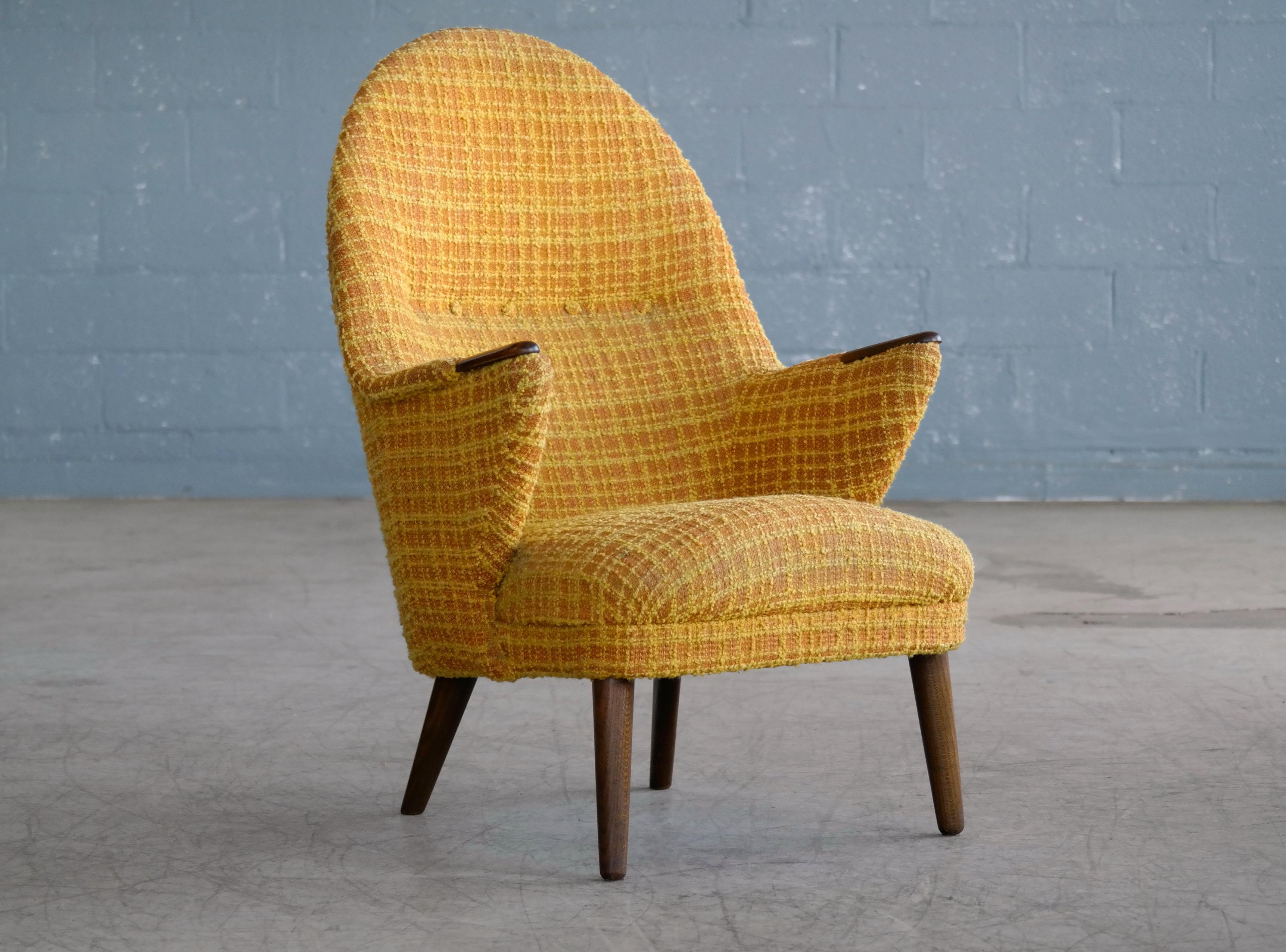 Very charming 1960s lounge chairs in the style of Hans Wegner's mama bear chair. It is a beautiful design with a very similar silhouette and stance to Wegner's chair raised on legs of teak and teak on the armrests. The chair is in overall good